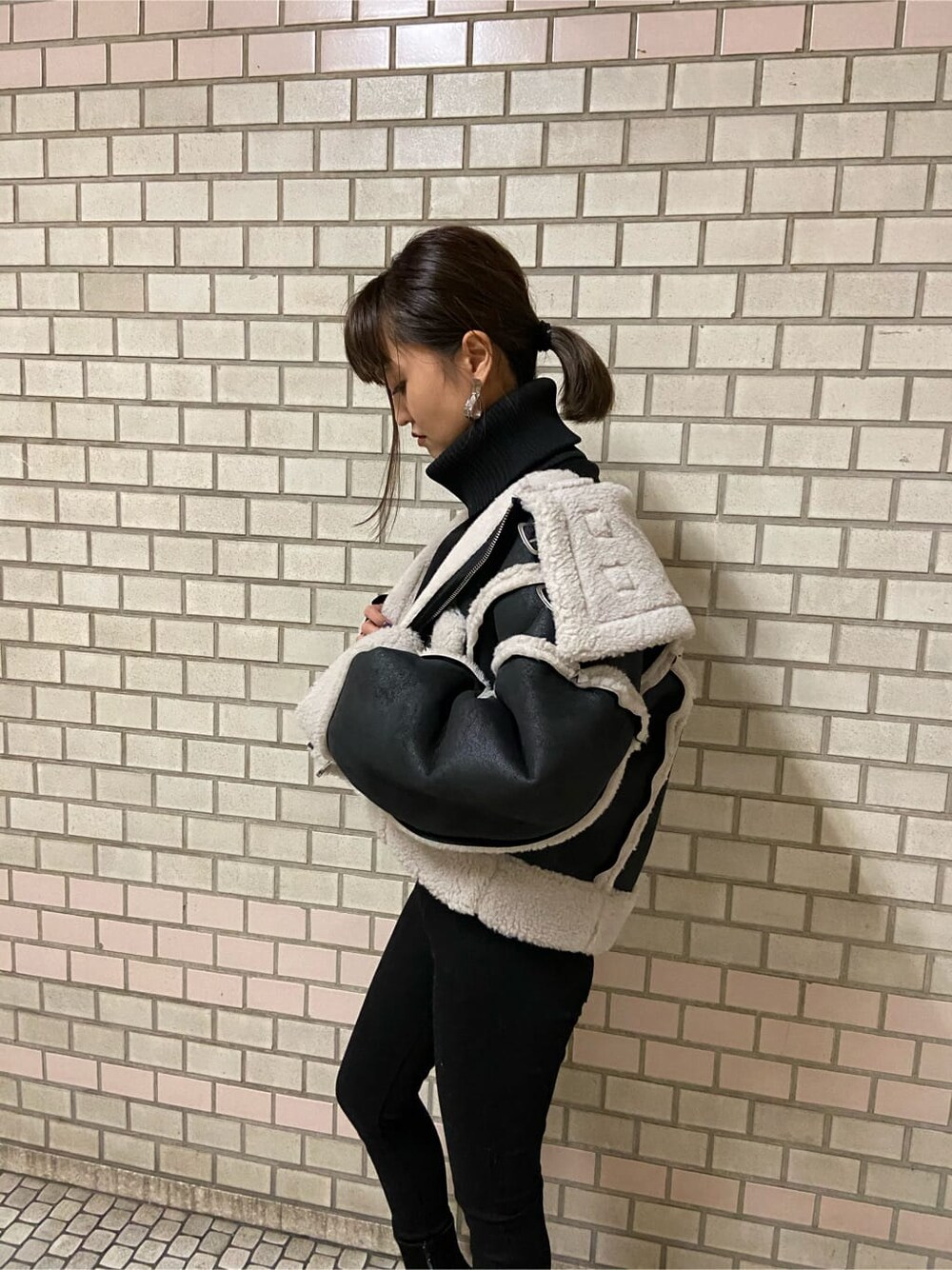 その他のムートンコート、ブラック系のブーツ、ブラック系のニット/セーターを着用したレディースの秋コーディネートの3枚目の写真