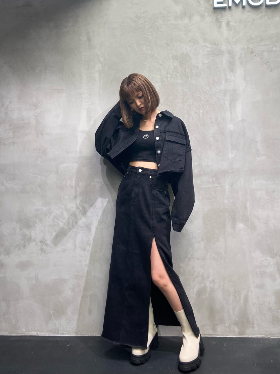 ブラック系のデニムジャケット、ブラック系のスカート、ホワイト系のブーツを着用したレディースの夏コーディネートの2枚目の写真