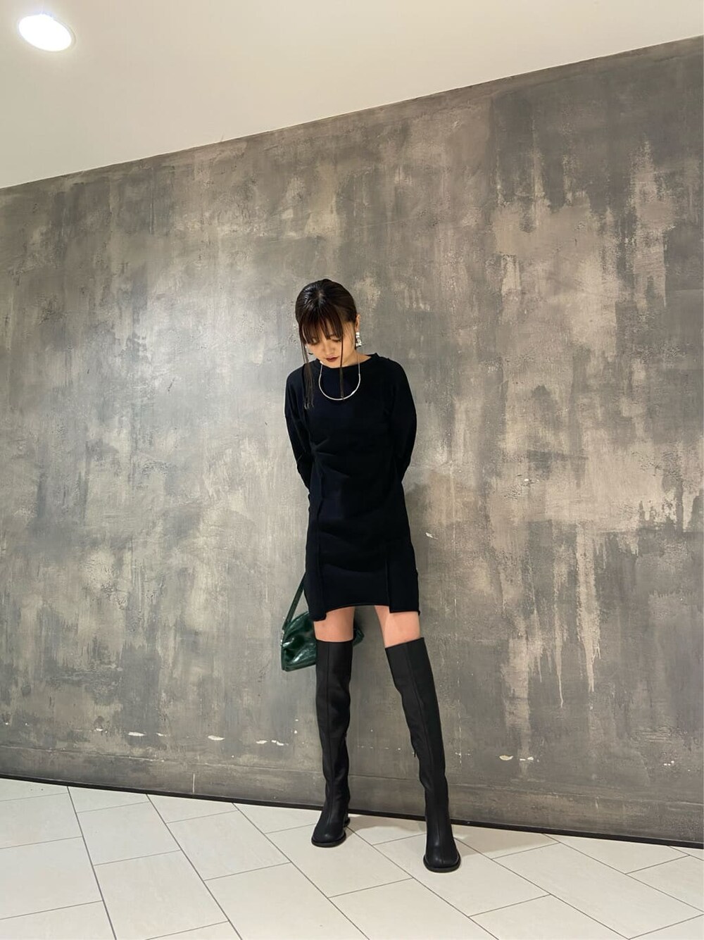 ブラック系のワンピース、ブラック系のブーツ、グリーン系のボディバッグ/ウエストポーチを着用したレディースの秋コーディネートの5枚目の写真