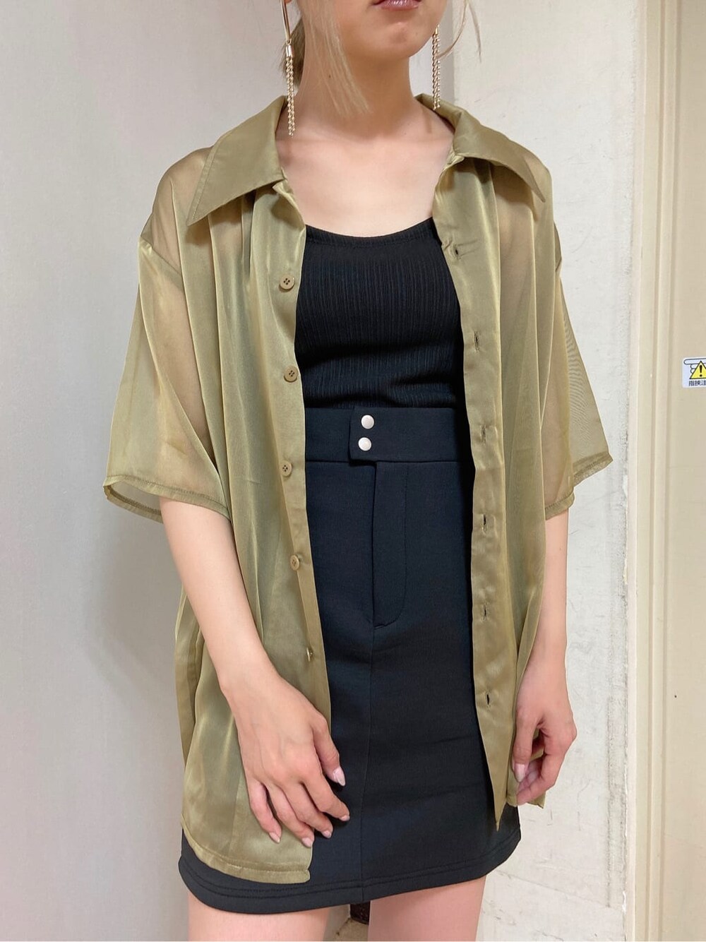 イエロー系のシャツ/ブラウス、ブラック系のスカート、ブラック系のサンダルを着用したレディースの夏コーディネートの2枚目の写真