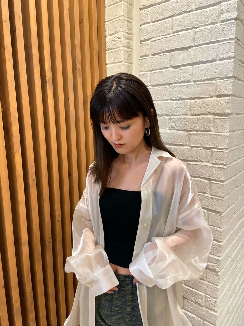 ブラック系のキャミソール、ホワイト系のシャツ/ブラウス、ブラック系のサンダルを着用したレディースの春コーディネートの5枚目の写真