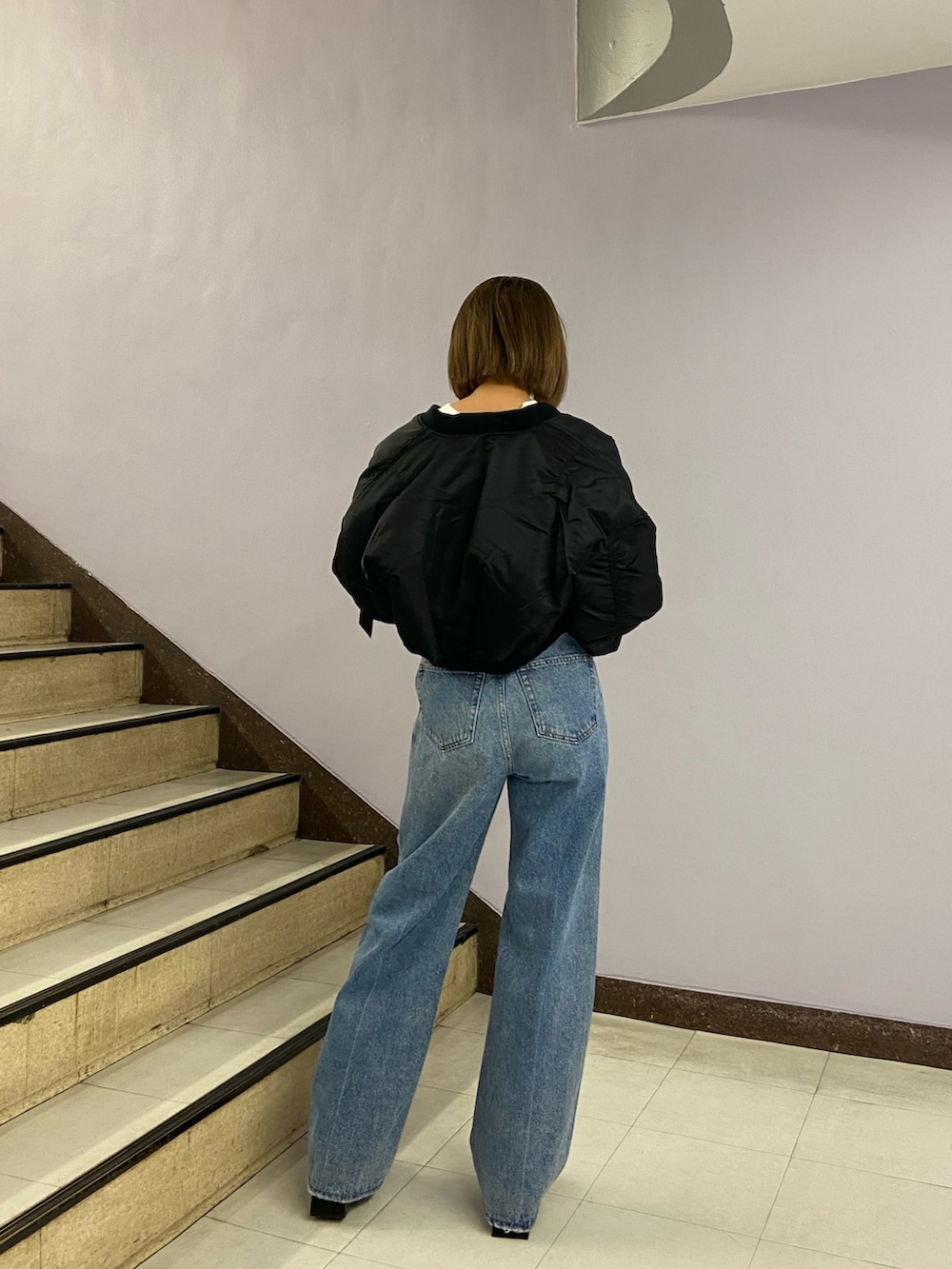 ブルー系のデニムパンツ、ブラック系のブーツ、ホワイト系のスウェットを着用したレディースの秋コーディネートの4枚目の写真