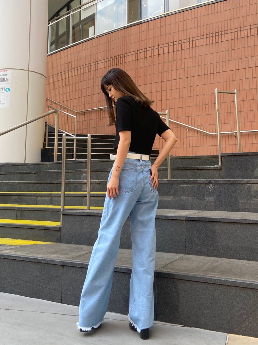 ブラック系のサンダル、ブルー系のデニムパンツ、ブラック系のTシャツ/カットソーを着用したレディースの春コーディネートの3枚目の写真