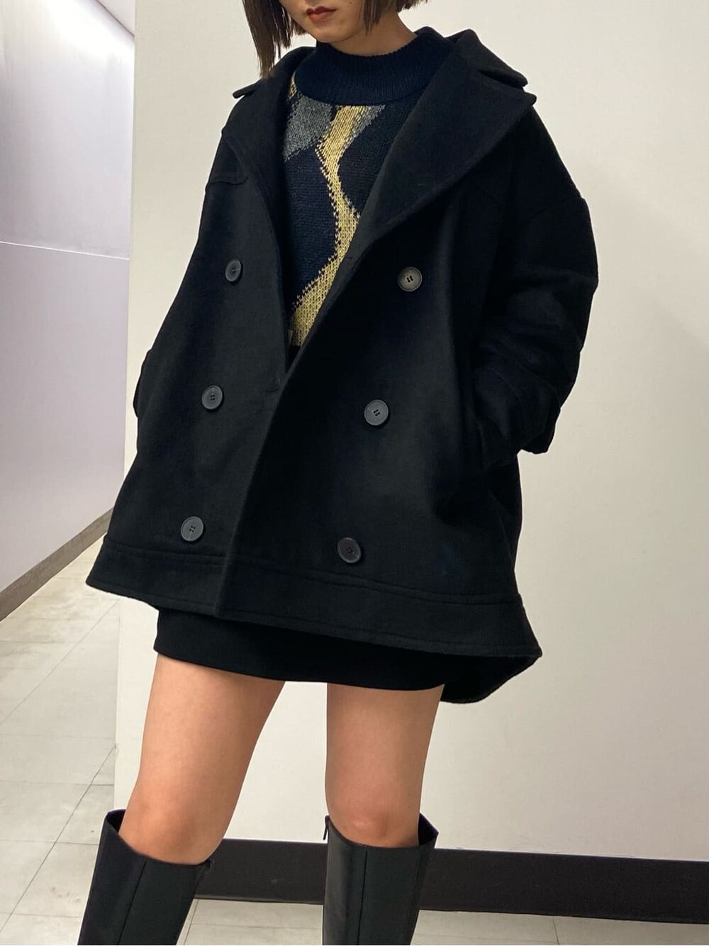 ブラック系のブーツ、ブラック系のスカート、ブラック系のテーラードジャケットを着用したレディースの秋コーディネートの3枚目の写真