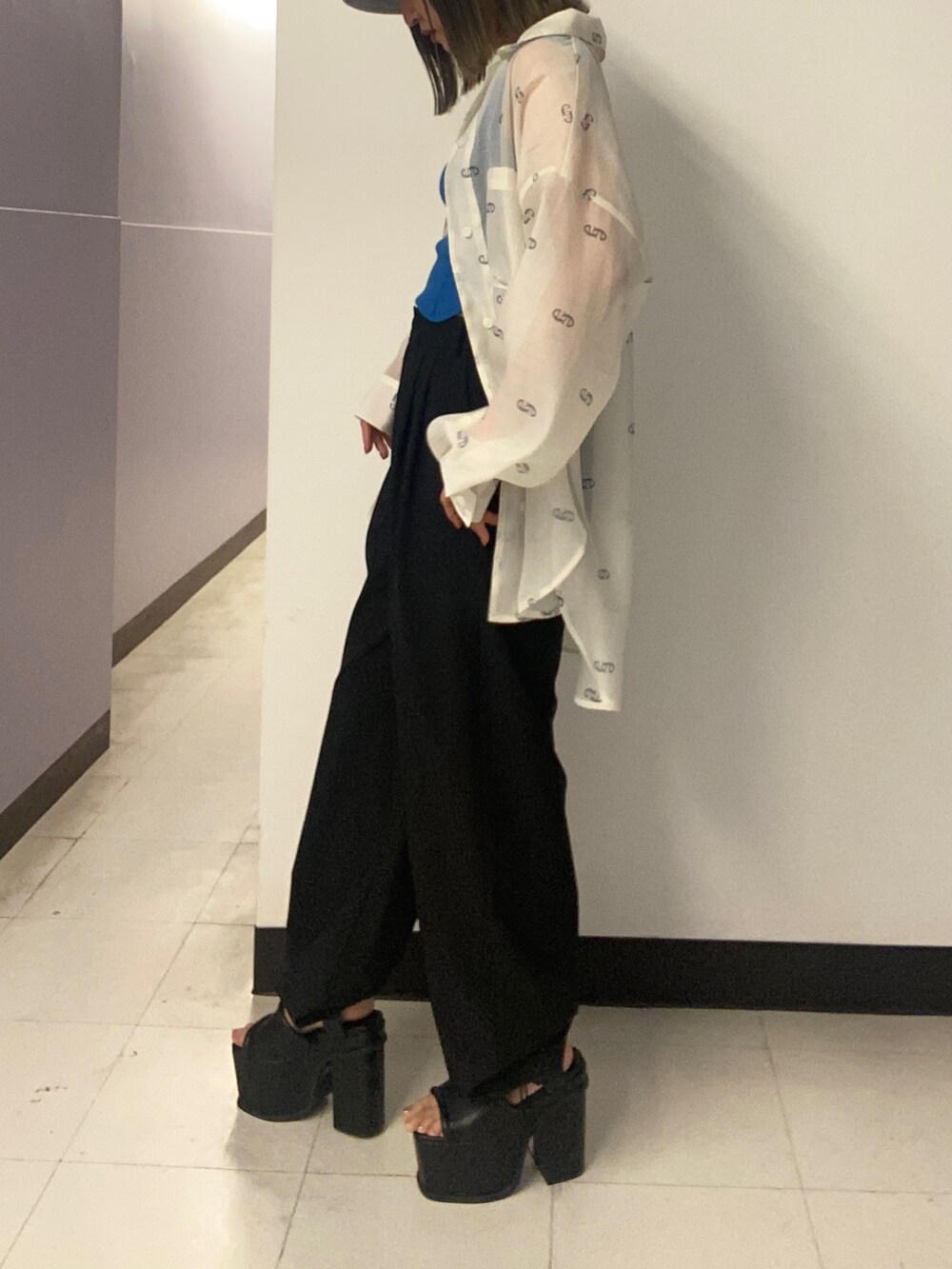 ホワイト系のシャツ/ブラウス、ブルー系のニット/セーター、ブラック系のその他パンツを着用したレディースの春コーディネートの2枚目の写真