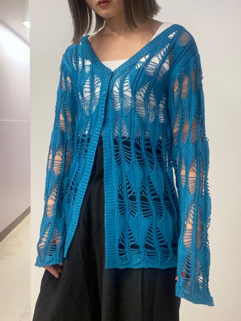 ブルー系のカーディガン/ボレロ、ホワイト系のニット/セーター、ブラック系のその他パンツを着用したレディースの春コーディネートの4枚目の写真