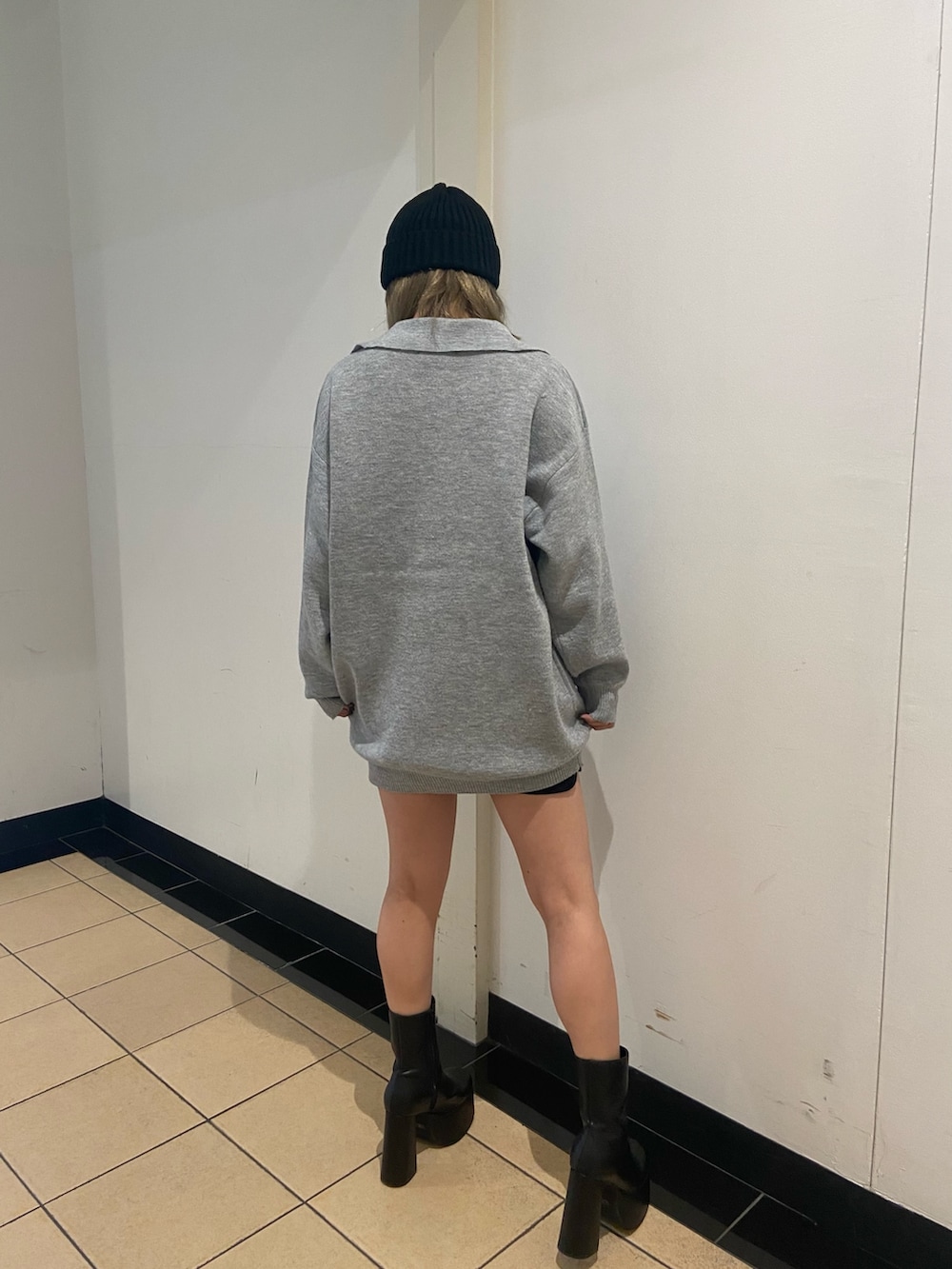 グレー系のワンピース、ブラック系のブーツ、ブラック系のニットキャップ/ビーニーを着用したレディースの秋コーディネートの4枚目の写真