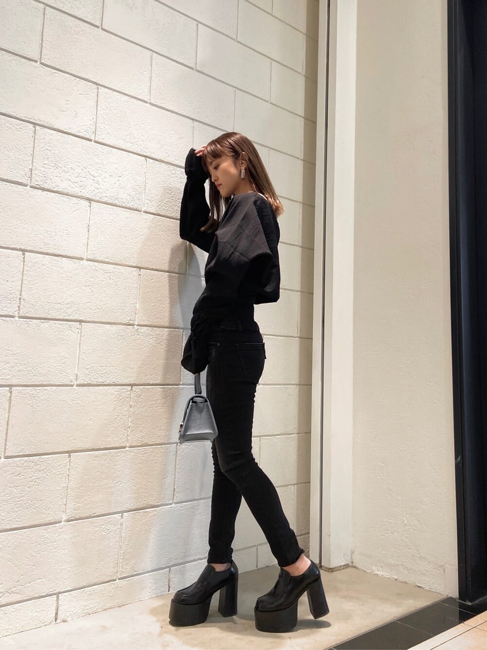 ブラック系のローファー、ブルー系のハンドバッグ、ブラック系のシャツ/ブラウスを着用したレディースの冬コーディネートの2枚目の写真