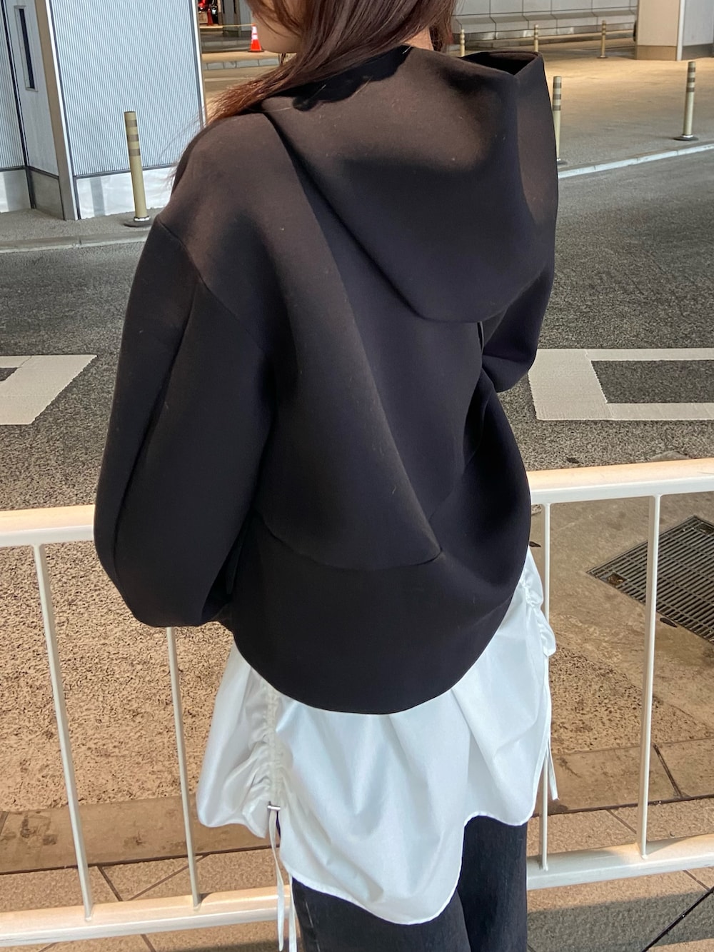 ブラック系のパーカー、ブラック系のデニムパンツ、シルバー系のローファーを着用したレディースの冬コーディネートの5枚目の写真
