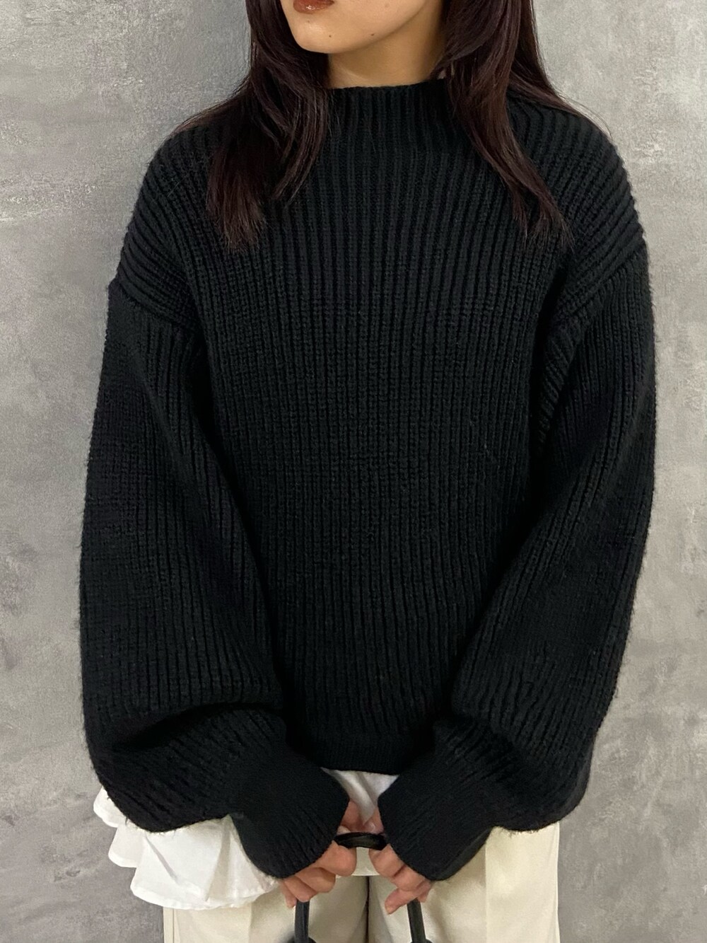 ブラック系のニット/セーター、ホワイト系のその他パンツ、ブラック系のブーツを着用したレディースの冬コーディネートの4枚目の写真