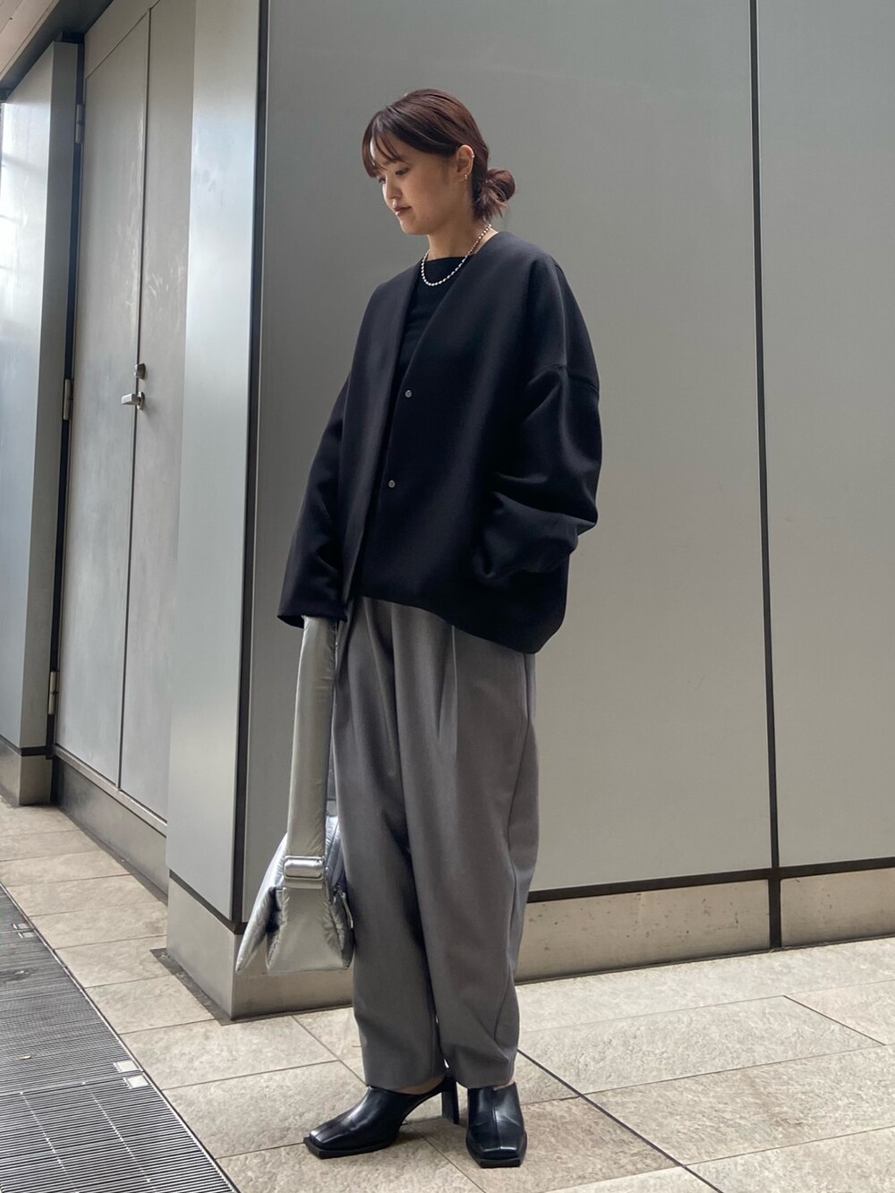 ブラック系のその他アウター、ブラック系のTシャツ/カットソー、グレー系のその他パンツを着用したレディースの冬コーディネートの2枚目の写真