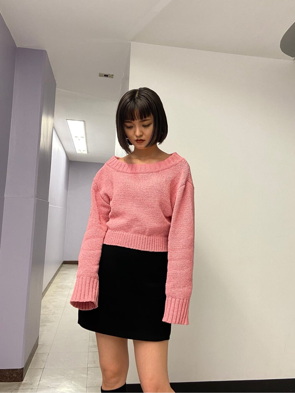 ブラック系のブーツ、ブラック系のスカート、ピンク系のニット/セーターを着用したレディースの秋コーディネートの4枚目の写真