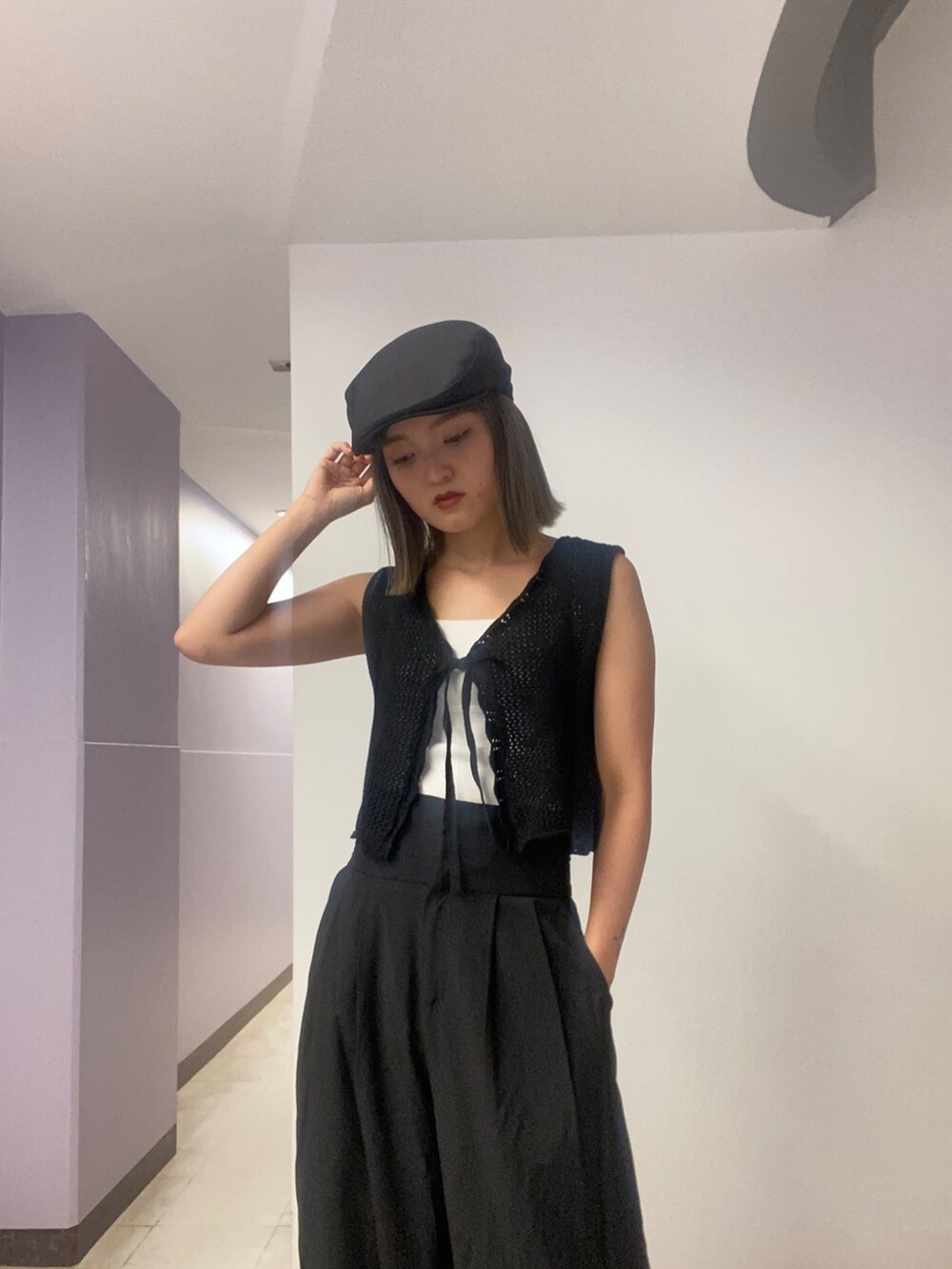 ブラック系のニット/セーター、ホワイト系のニット/セーター、ブラック系のその他パンツを着用したレディースの春コーディネートの3枚目の写真