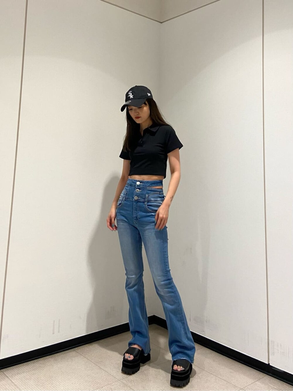 ブルー系のデニムパンツ、ブラック系のサンダル、ブラック系のTシャツ/カットソーを着用したレディースの夏コーディネートの2枚目の写真