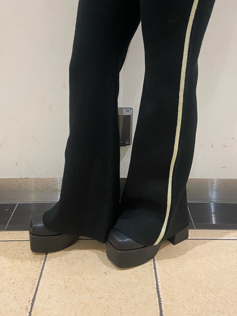 ブラック系のニット/セーター、ブラック系のその他パンツ、ブラック系のブーツを着用したレディースの秋コーディネートの5枚目の写真