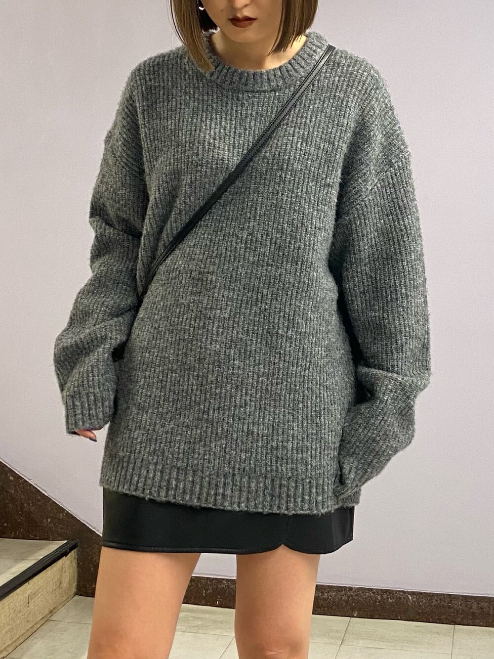 グレー系のニット/セーター、ブラック系のショルダーバッグ、その他のスカートを着用したレディースの秋コーディネートの6枚目の写真