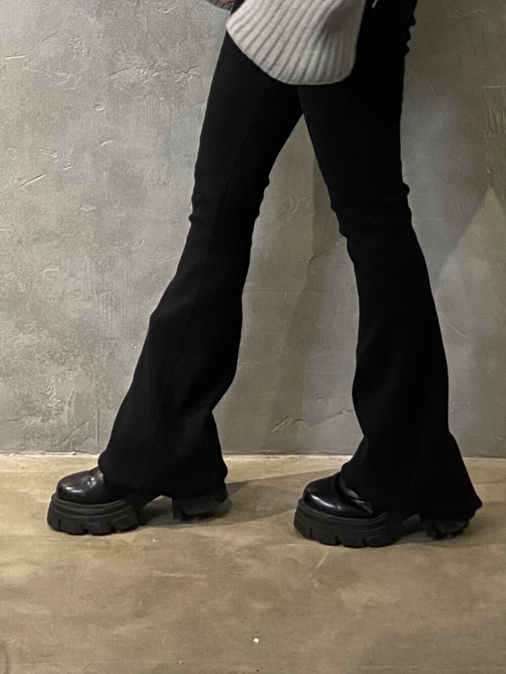 グレー系のニット/セーター、ブラック系のブーツ、ブラック系のその他パンツを着用したレディースの冬コーディネートの7枚目の写真