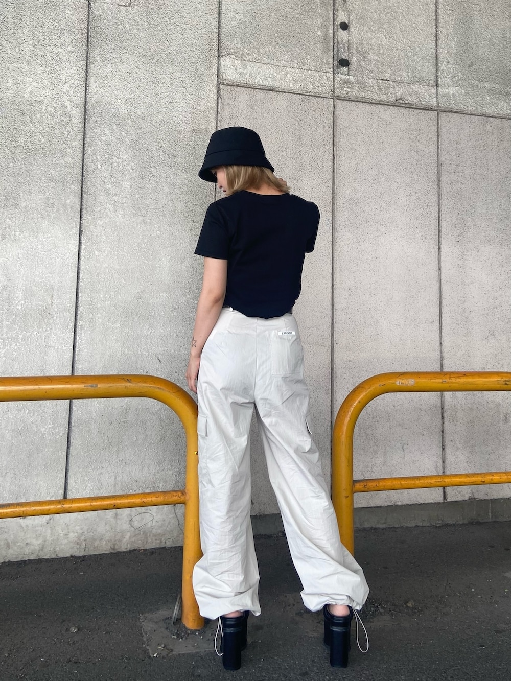 ブラック系のTシャツ/カットソー、ホワイト系のカーゴパンツ、ブラック系のサンダルを着用したレディースの夏コーディネートの4枚目の写真
