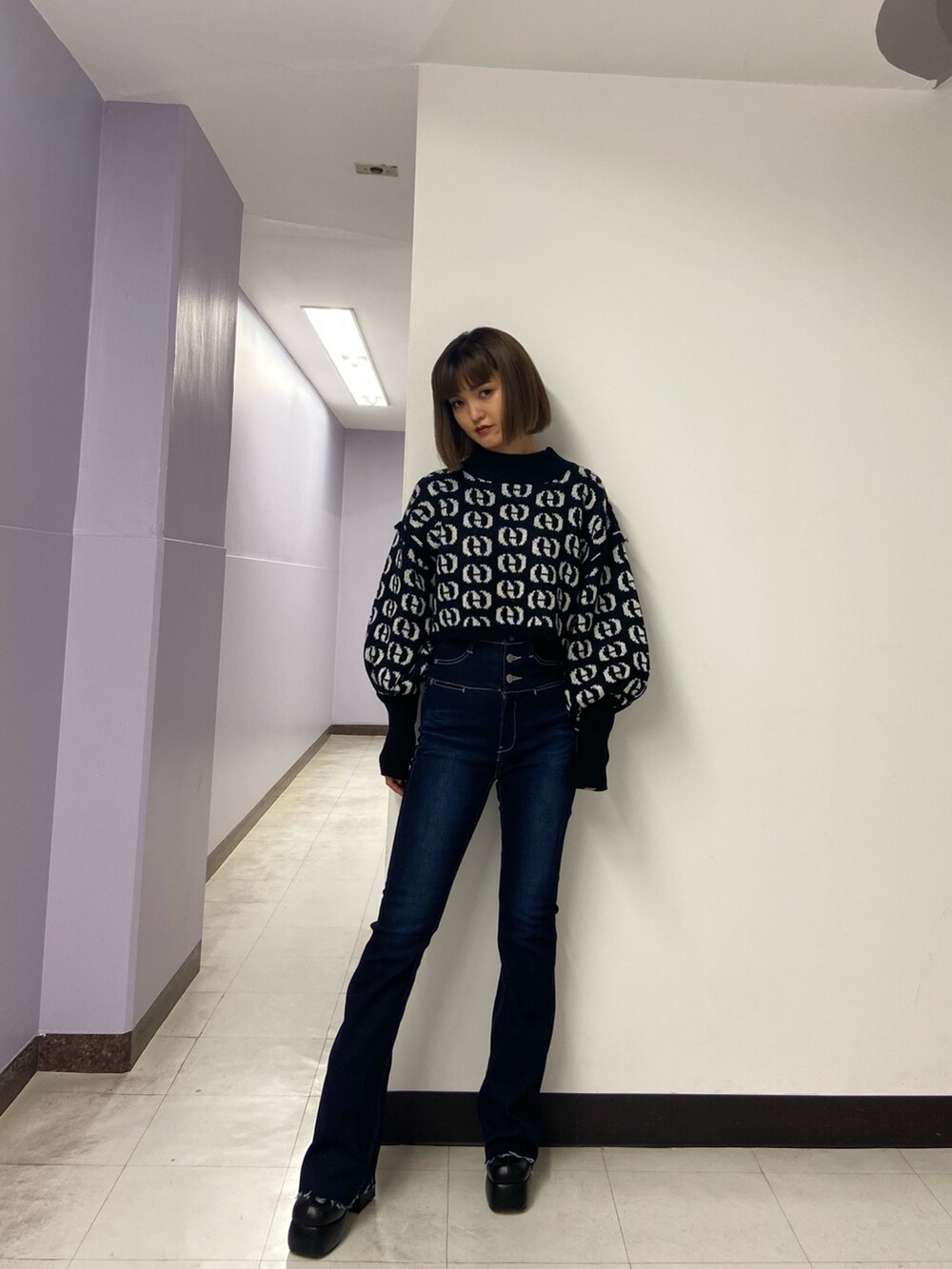 ブラック系のブーツ、ブルー系のデニムパンツ、その他のニット/セーターを着用したレディースの秋コーディネートの2枚目の写真