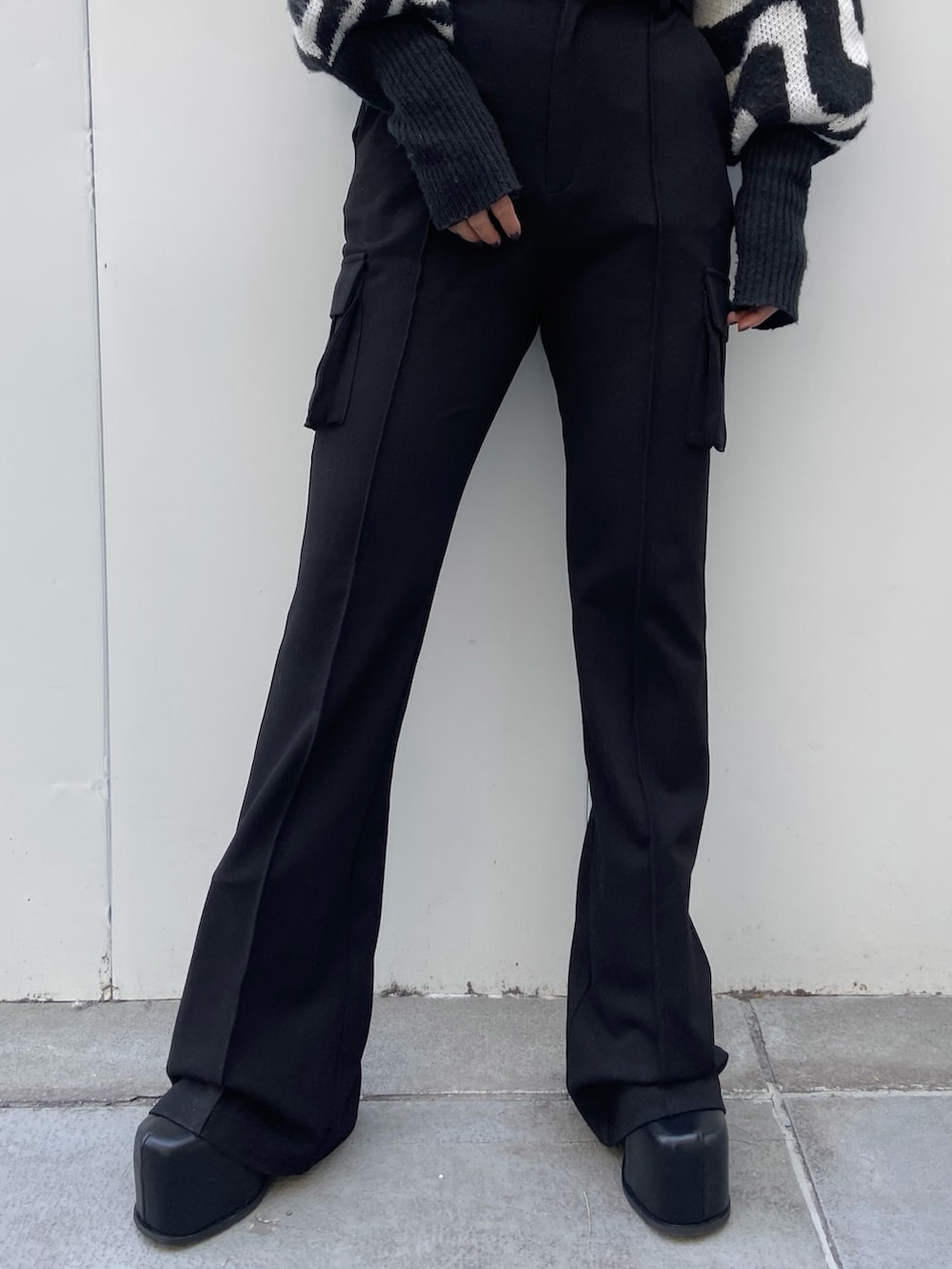 ブラック系のニット/セーター、ブラック系のカーゴパンツ、ブラック系のブーツを着用したレディースの冬コーディネートの5枚目の写真