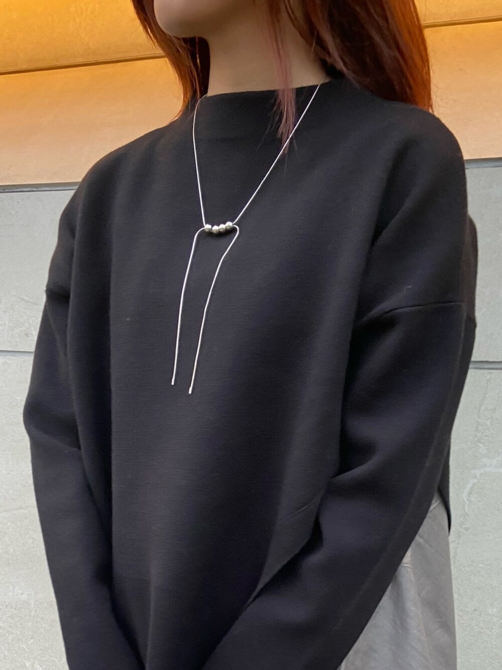 ブラック系のサンダル、ブラック系のニット/セーター、ホワイト系のスカートを着用したレディースの秋コーディネートの5枚目の写真