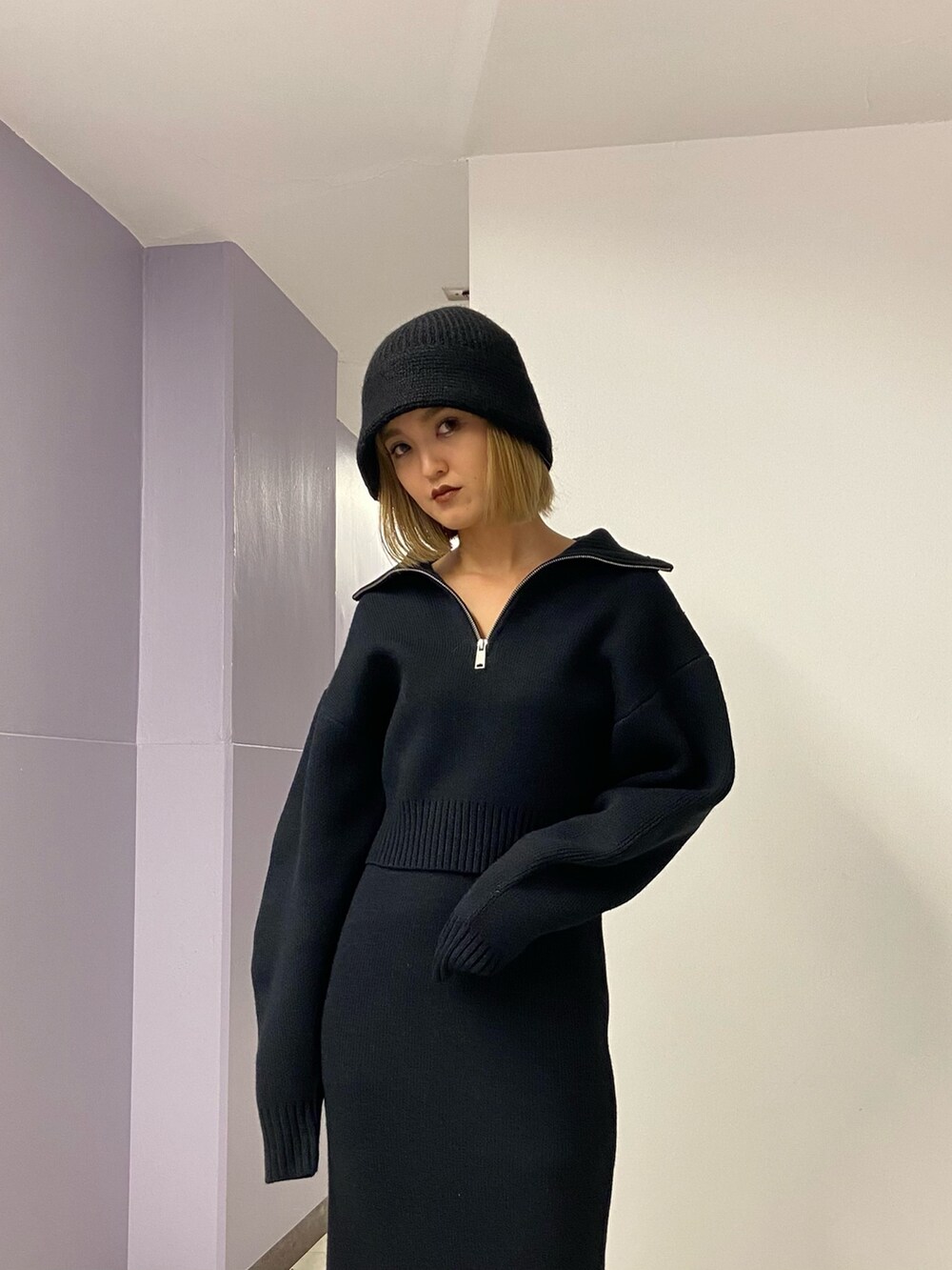 ブラック系のニット/セーター、ブラウン系のブーツ、ブラック系のスカートを着用したレディースの冬コーディネートの5枚目の写真