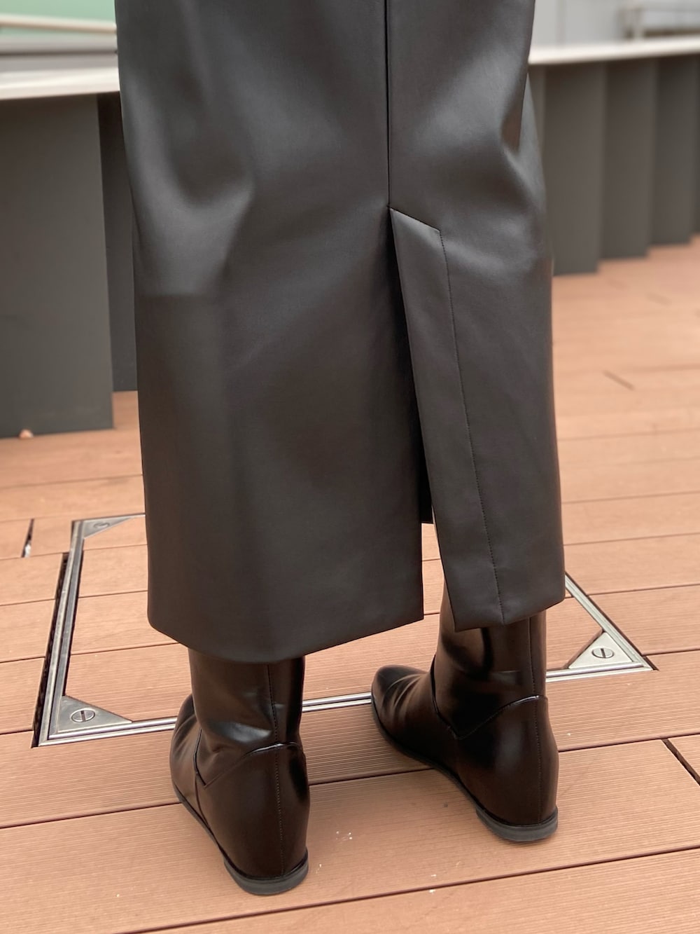 グレー系のニット/セーター、ブラック系のスカート、ブラック系のブーツを着用したレディースの秋コーディネートの7枚目の写真