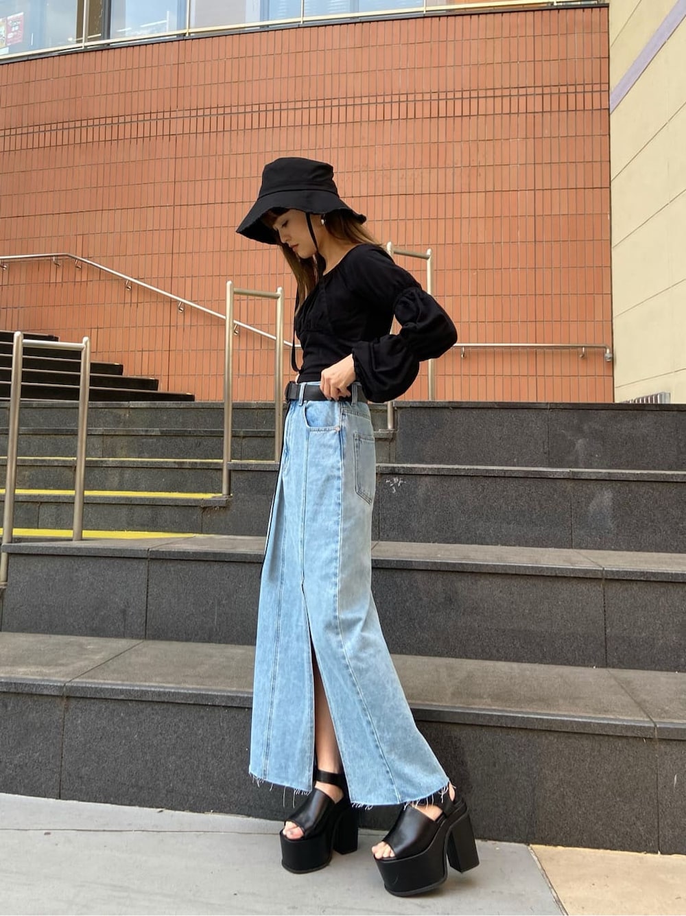 ブルー系のスカート、ブラック系のTシャツ/カットソー、ブラック系のサンダルを着用したレディースの春コーディネートの2枚目の写真