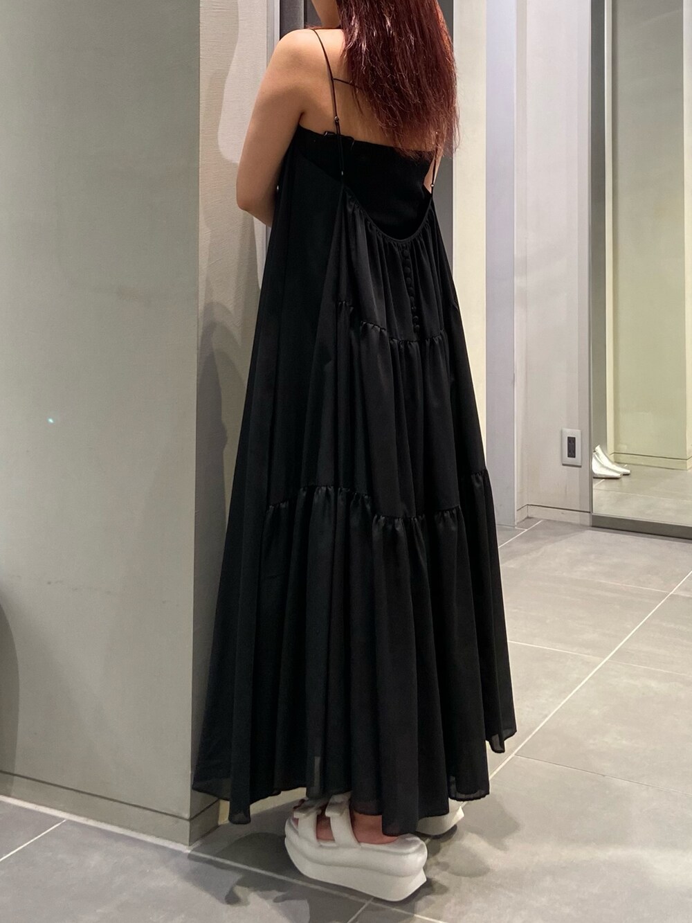 ホワイト系のサンダル、ブラック系のワンピース、ブラック系のキャミソールを着用したレディースの春コーディネートの2枚目の写真