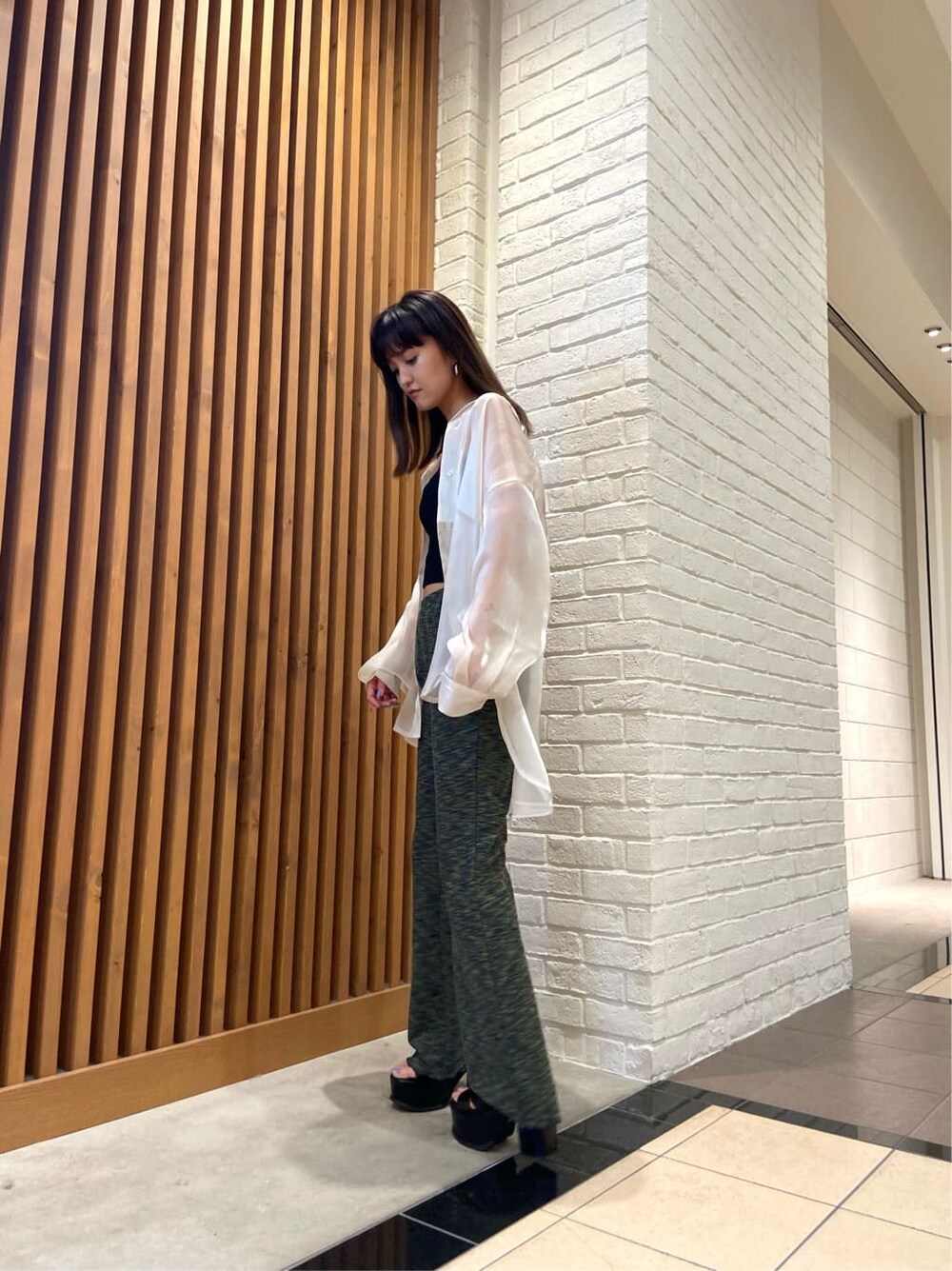 ブラック系のキャミソール、ホワイト系のシャツ/ブラウス、ブラック系のサンダルを着用したレディースの春コーディネートの3枚目の写真