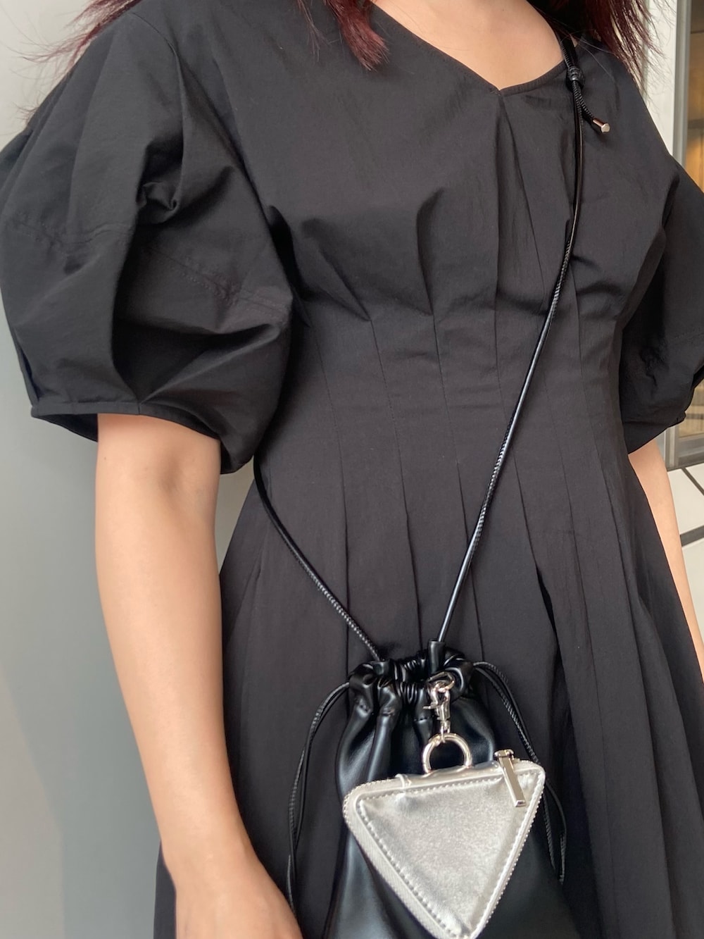 ブラック系のワンピース、ブラック系のショルダーバッグ、シルバー系のサンダルを着用したレディースの春コーディネートの5枚目の写真