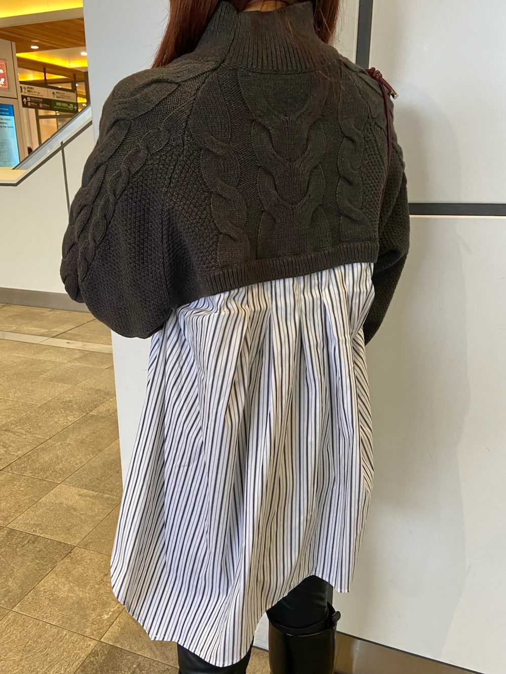 グレー系のブルゾン、ブラック系のブーツ、グレー系のニット/セーターを着用したレディースの秋コーディネートの5枚目の写真