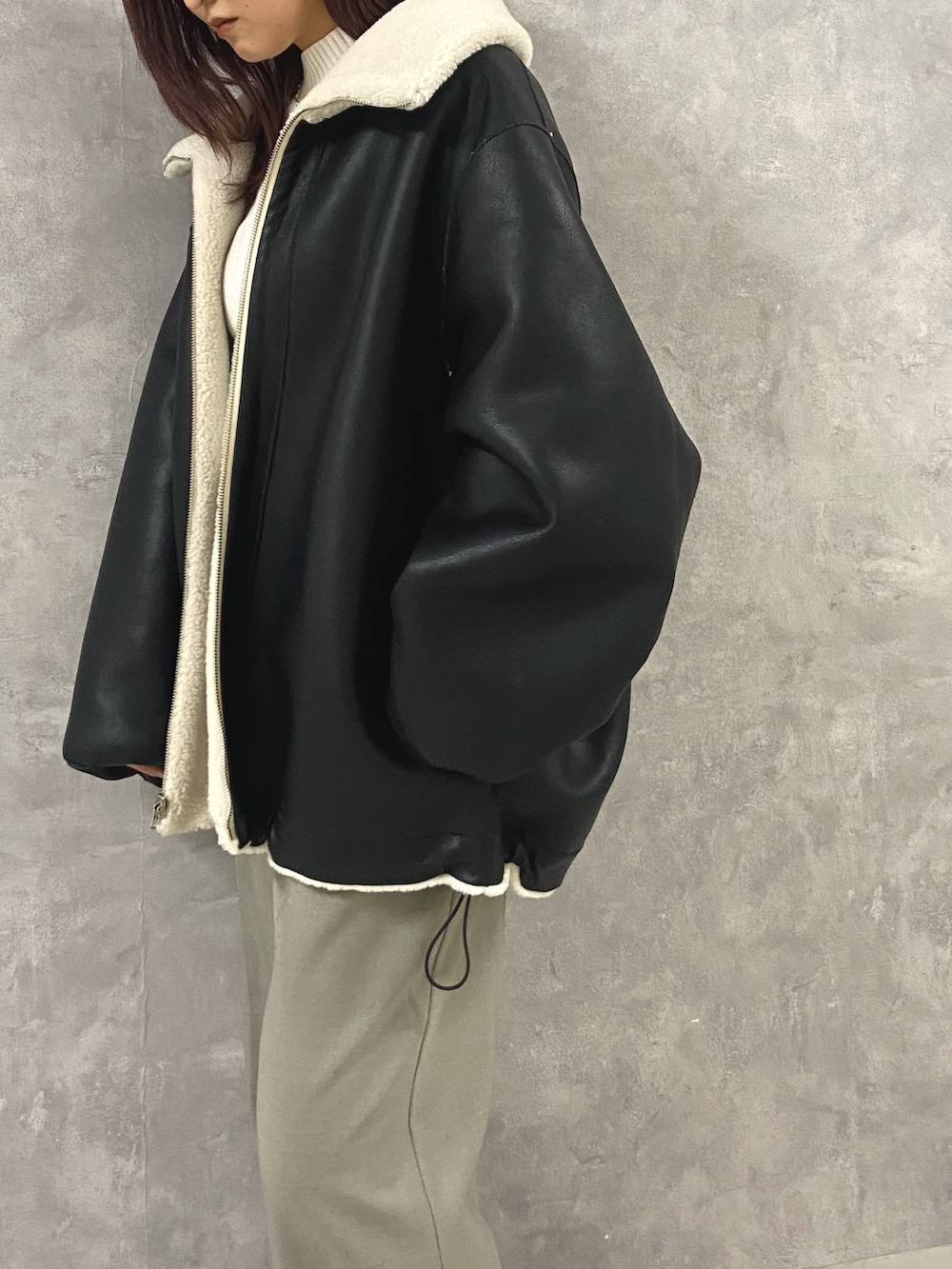 ホワイト系のその他アウター、ホワイト系のニット/セーター、グレー系のその他パンツを着用したレディースの秋コーディネートの5枚目の写真