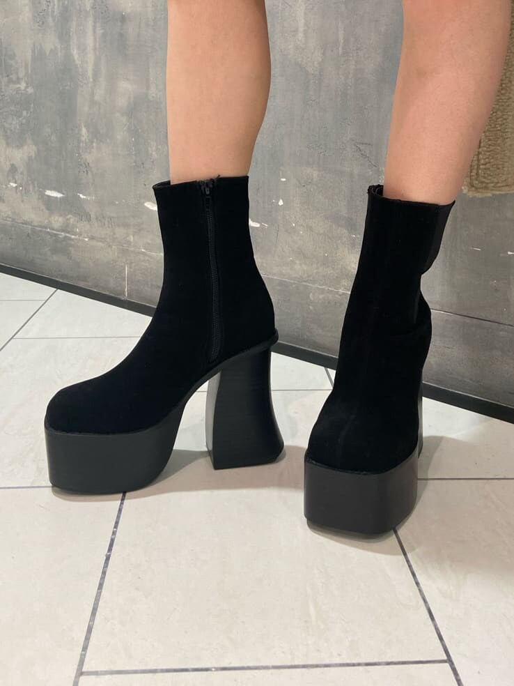 ブラック系のブーツ、ブラック系のワンピース、ブラック系のショルダーバッグを着用したレディースの冬コーディネートの5枚目の写真