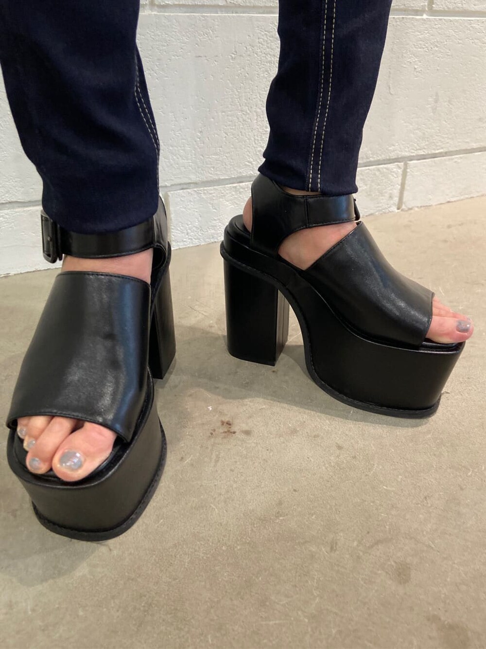 ブルー系のデニムパンツ、ブラック系のサンダル、その他のニット/セーターを着用したレディースの春コーディネートの9枚目の写真