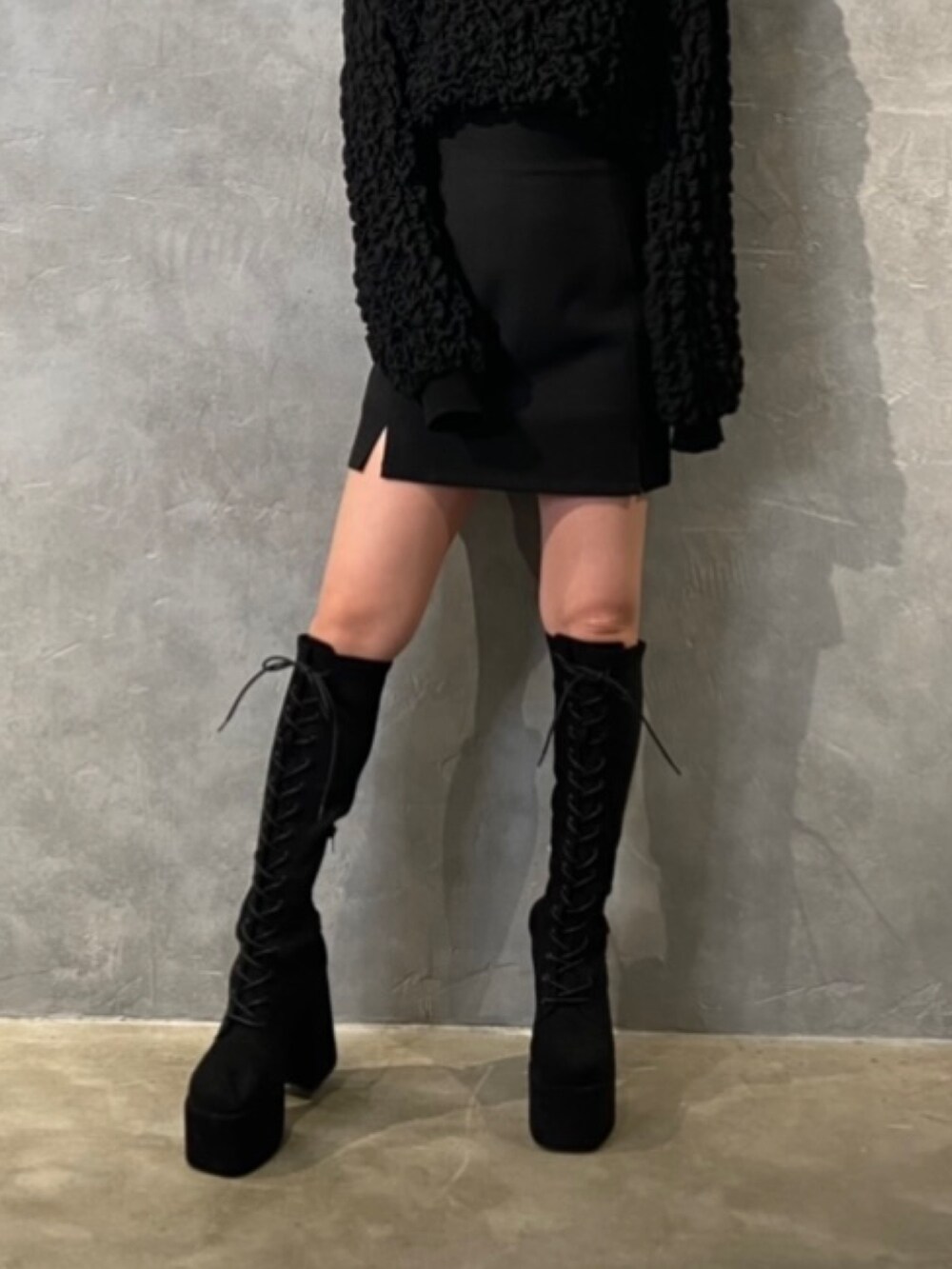 ブラック系のTシャツ/カットソー、ブラック系のスカート、ブラック系のブーツを着用したレディースの冬コーディネートの6枚目の写真