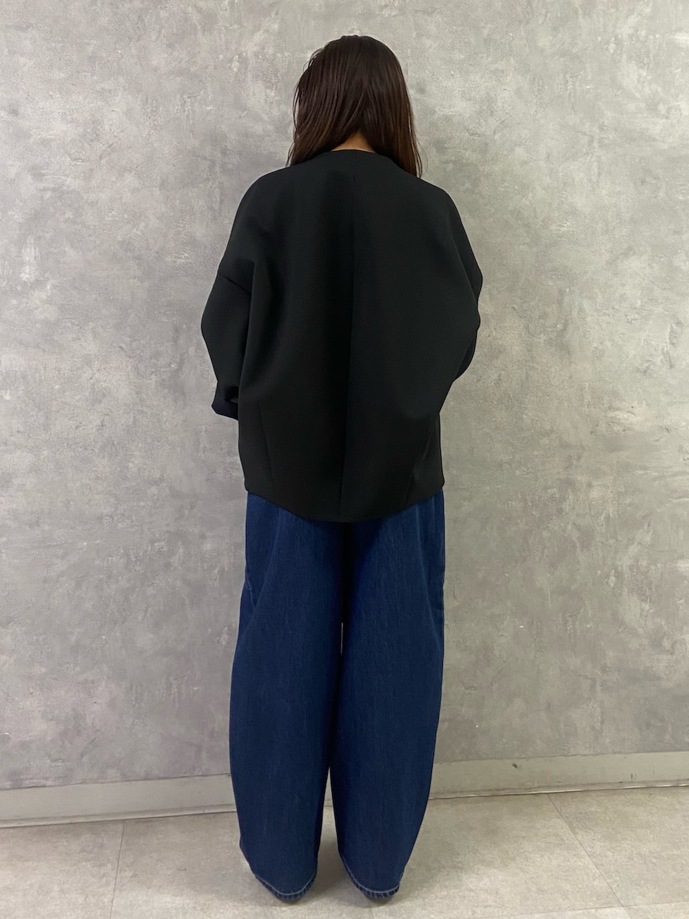 ブラック系のその他アウター、ホワイト系のTシャツ/カットソー、ブルー系のデニムパンツを着用したレディースの冬コーディネートの6枚目の写真