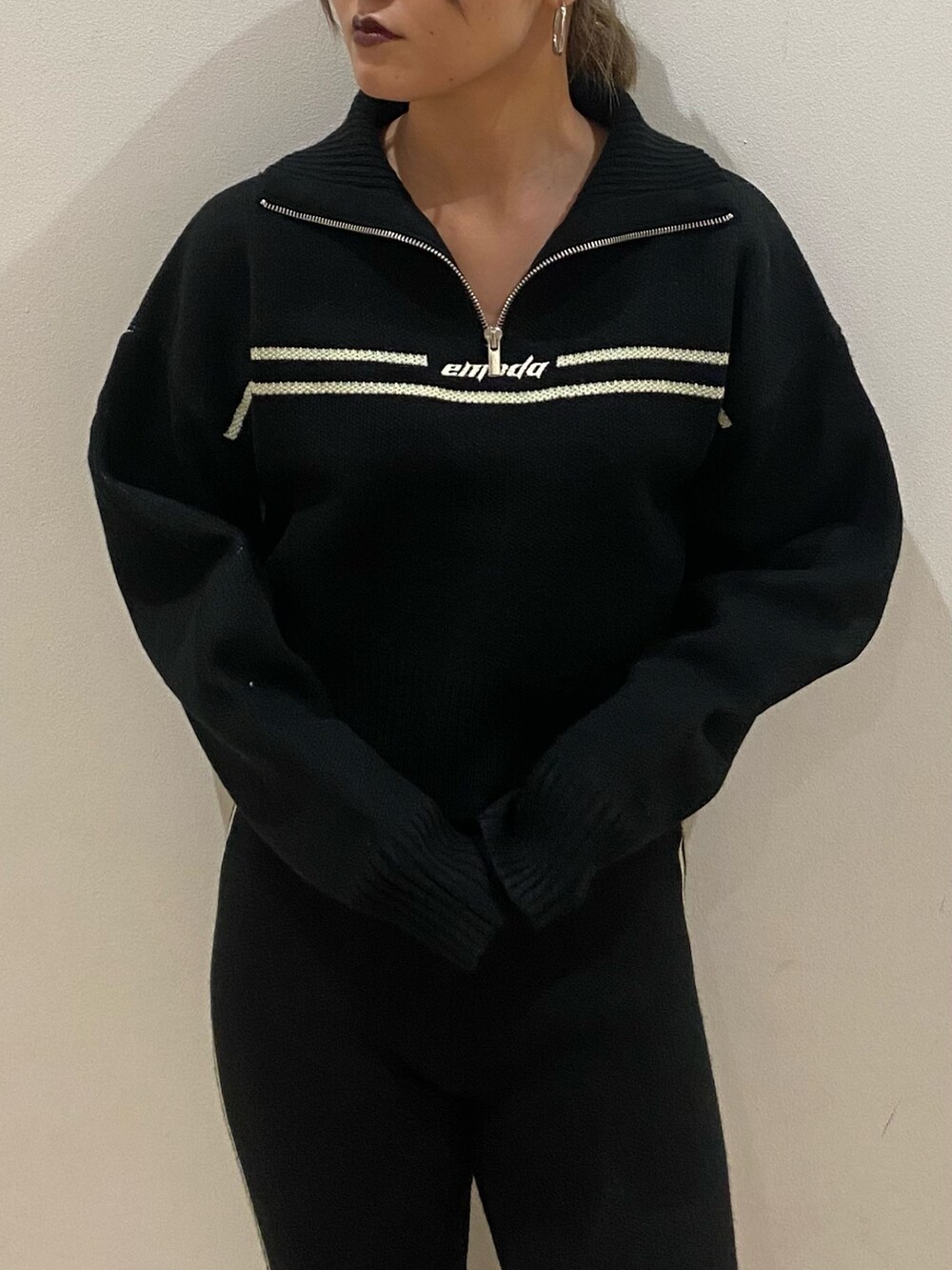 ブラック系のニット/セーター、ブラック系のその他パンツ、ブラック系のブーツを着用したレディースの秋コーディネートの4枚目の写真