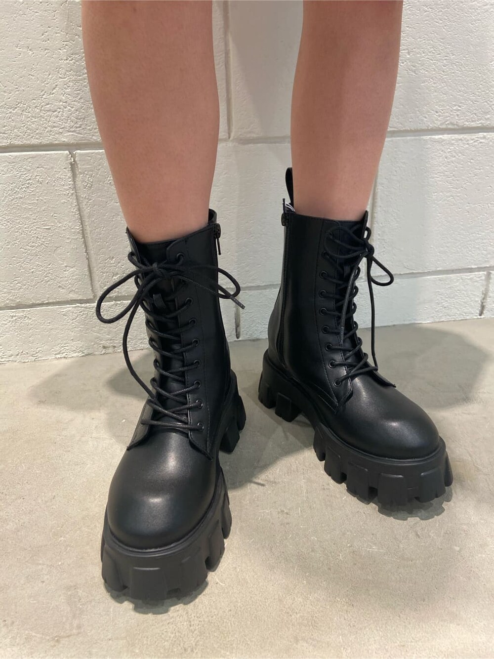 ブラック系のブーツ、ホワイト系のTシャツ/カットソー、ブラック系のハットを着用したレディースの冬コーディネートの5枚目の写真