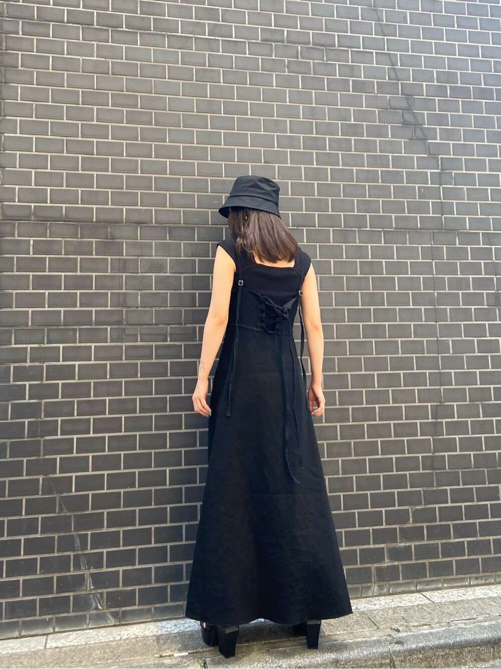 ブラック系のワンピース、ブラック系のサンダル、ブラック系のタンクトップを着用したレディースの夏コーディネートの2枚目の写真