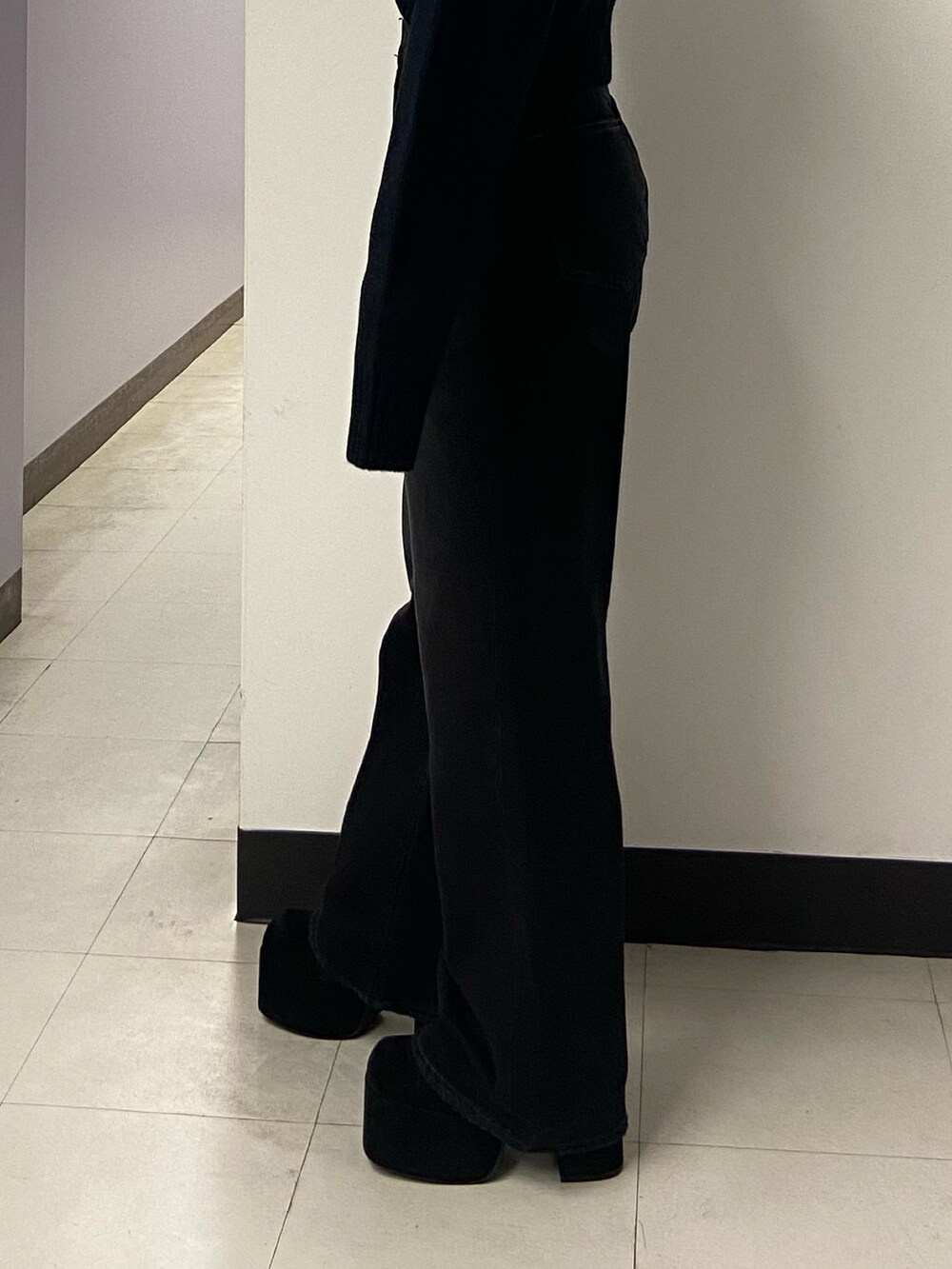 ブラック系のデニムパンツ、ブラック系のブーツ、ブラック系のニット/セーターを着用したレディースの秋コーディネートの7枚目の写真