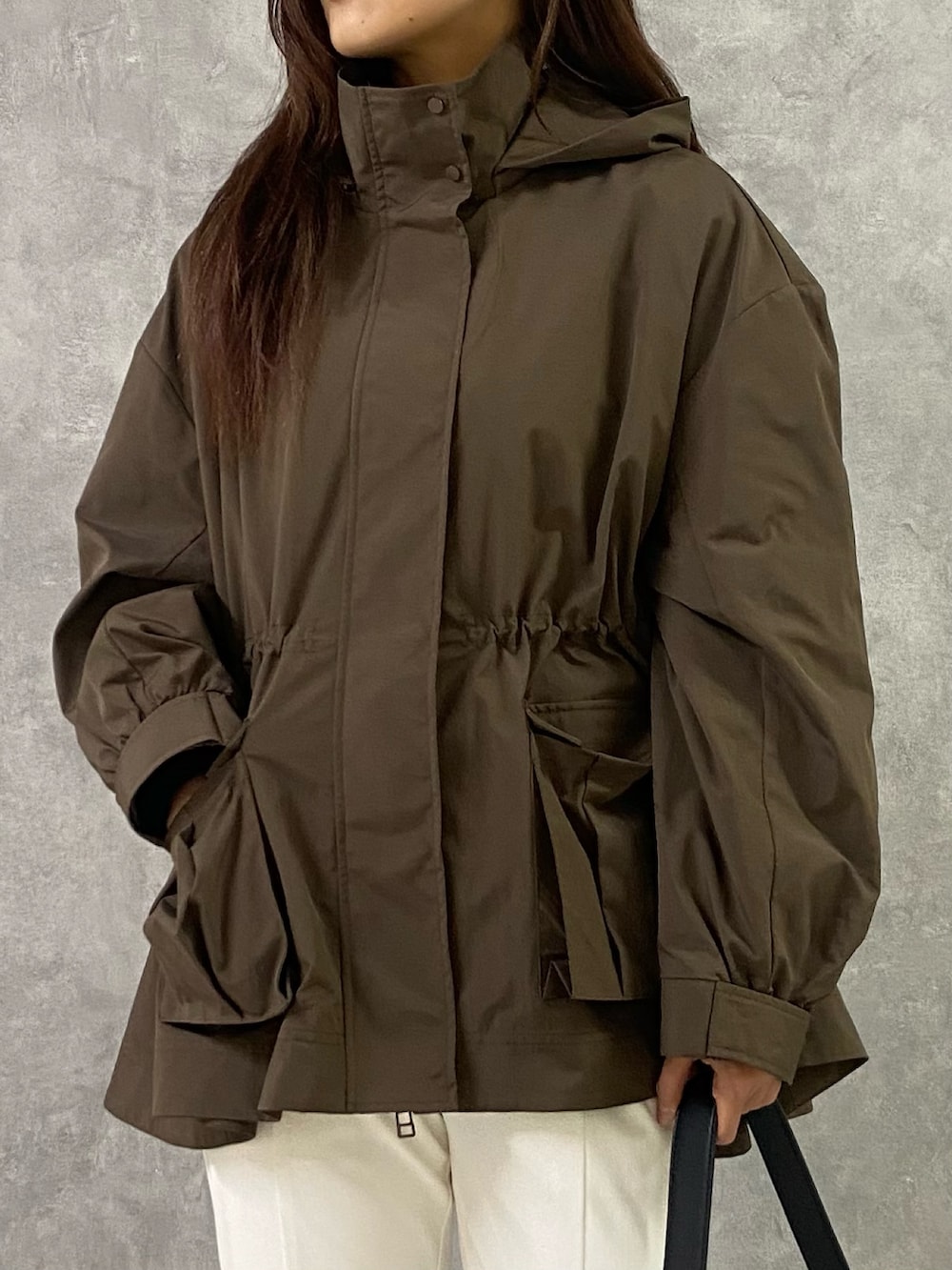 ブラウン系のブルゾン、ブラック系のTシャツ/カットソー、ブラック系のショルダーバッグを着用したレディースの冬コーディネートの4枚目の写真