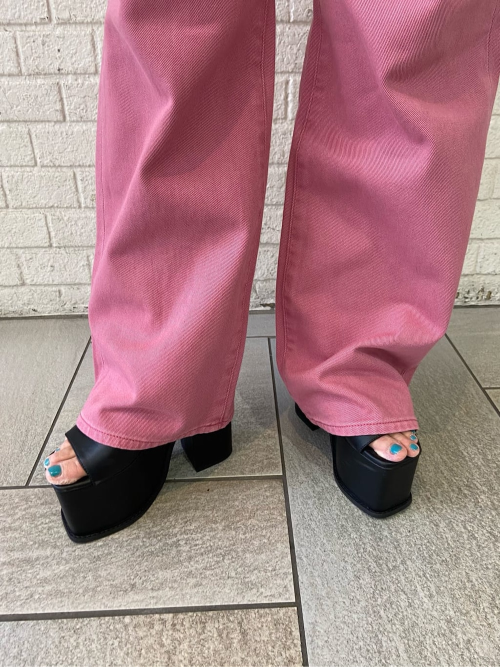 ピンク系のデニムパンツ、ブラック系のサンダル、ブラック系のTシャツ/カットソーを着用したレディースの夏コーディネートの7枚目の写真