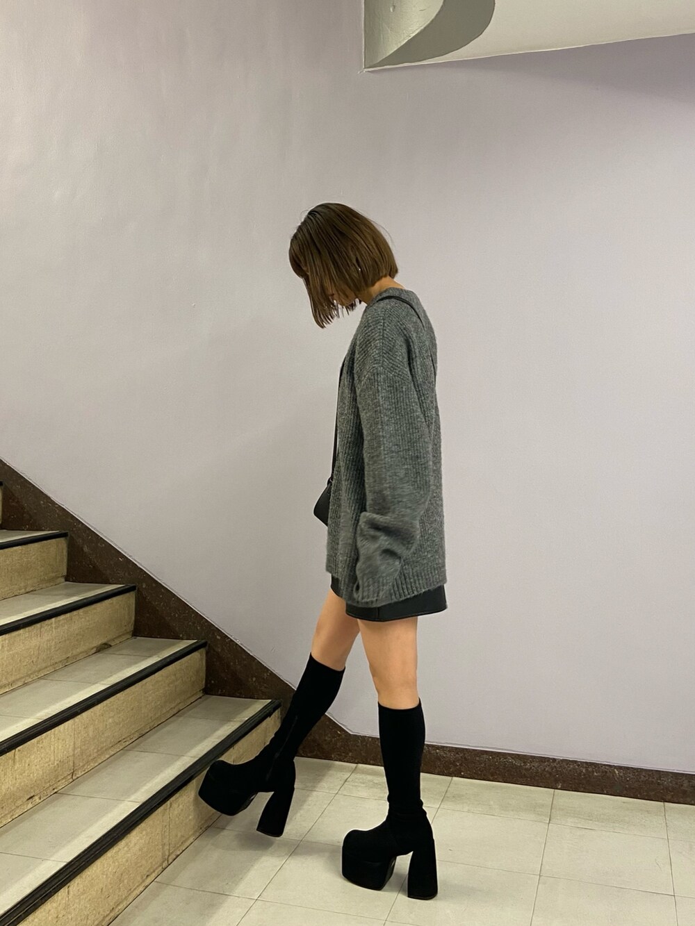 グレー系のニット/セーター、ブラック系のショルダーバッグ、その他のスカートを着用したレディースの秋コーディネートの4枚目の写真