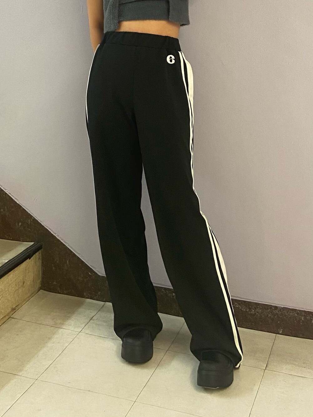 グレー系のニット/セーター、ブラック系のその他パンツ、ブラック系のブーツを着用したレディースの夏コーディネートの5枚目の写真