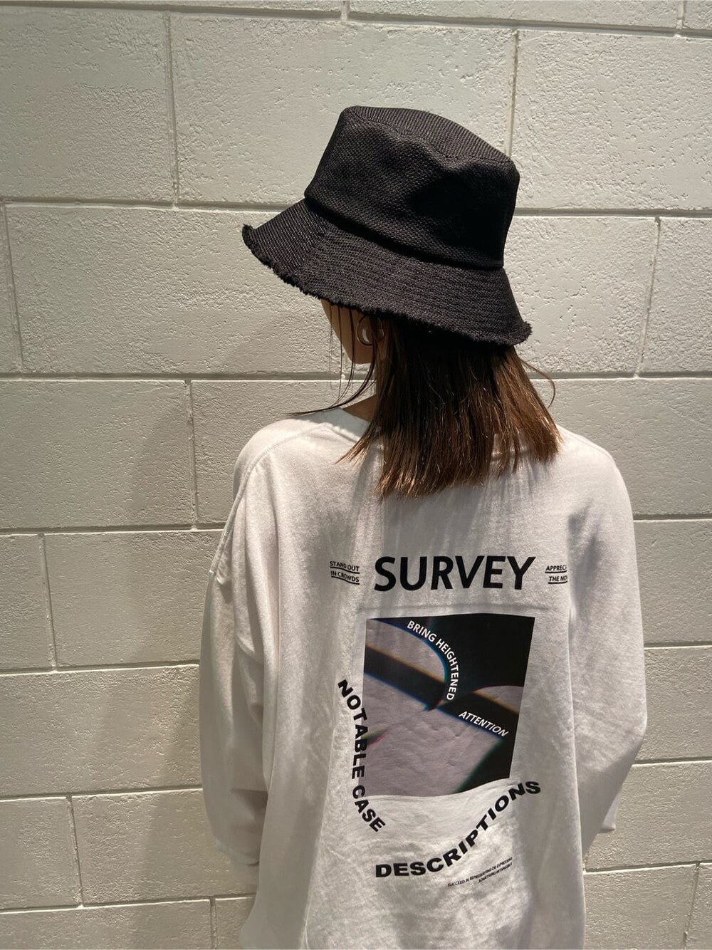 ブラック系のブーツ、ホワイト系のTシャツ/カットソー、ブラック系のハットを着用したレディースの冬コーディネートの4枚目の写真