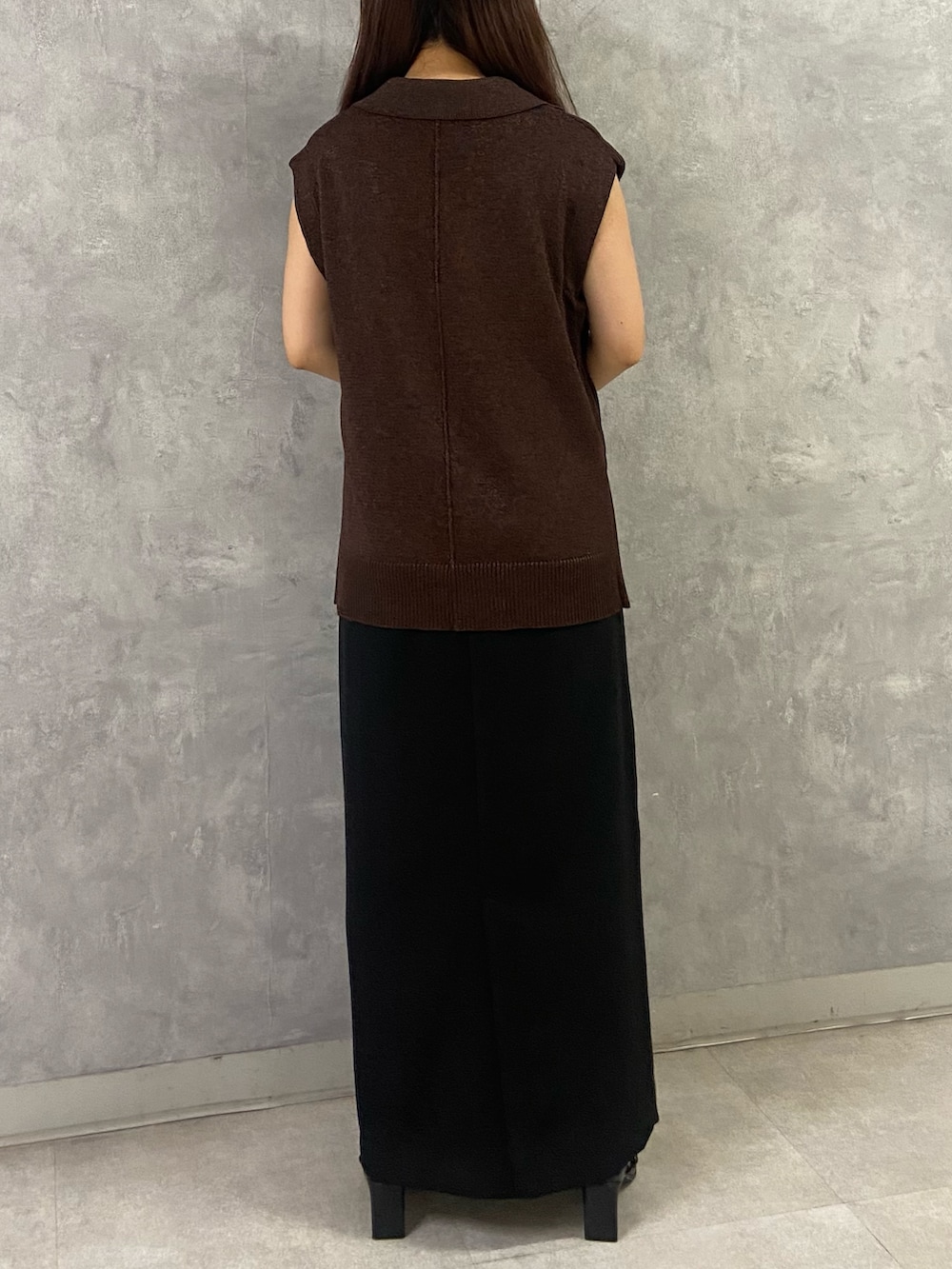 ブラウン系のベスト、ブラック系のワンピース、ブラック系のサンダルを着用したレディースの夏コーディネートの3枚目の写真