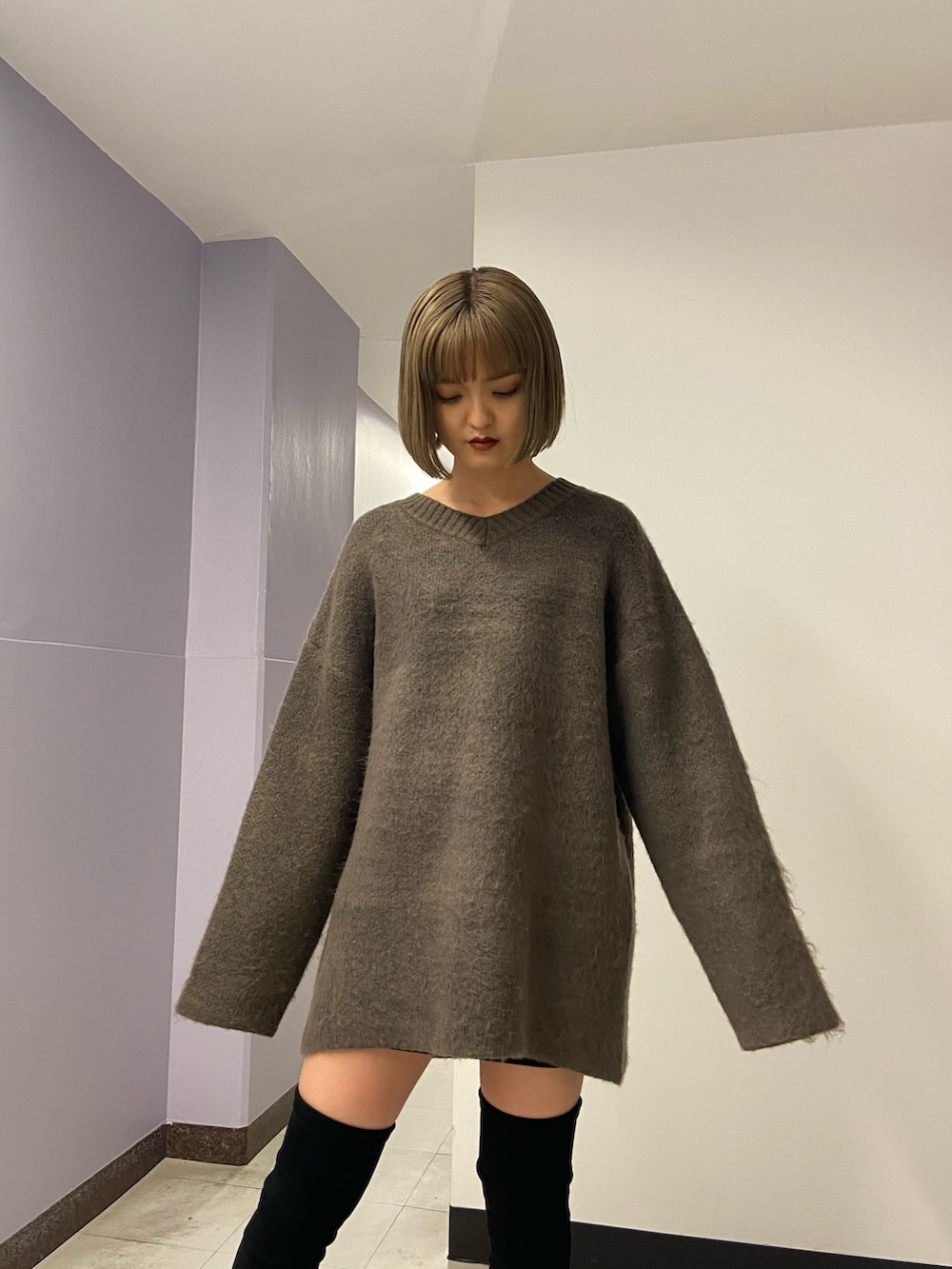 ブラウン系のニット/セーター、ブラック系のスカート、ブラック系のブーツを着用したレディースの冬コーディネートの5枚目の写真