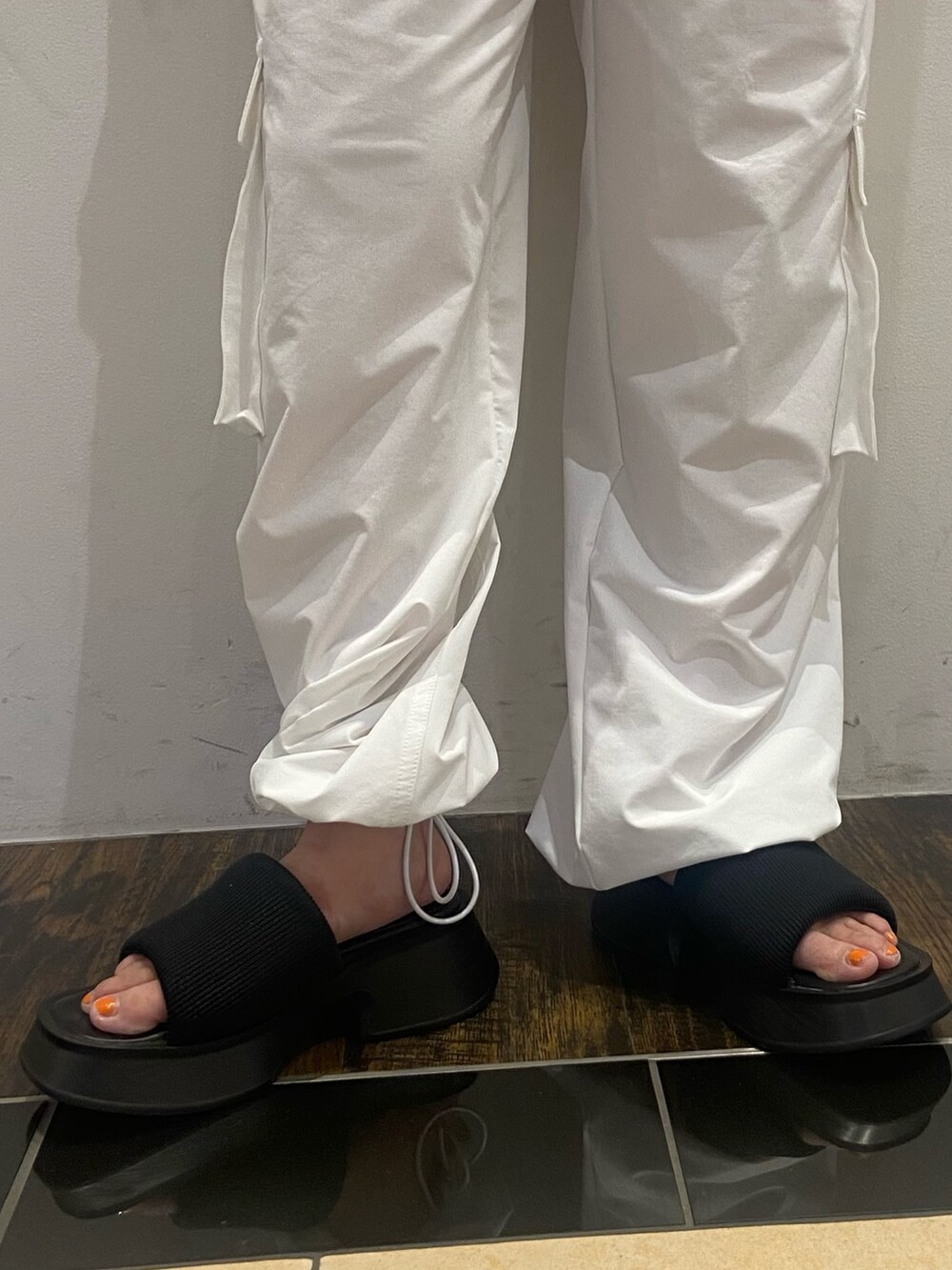 ブラック系のTシャツ/カットソー、ホワイト系のその他パンツ、ブラック系のサンダルを着用したレディースの夏コーディネートの6枚目の写真