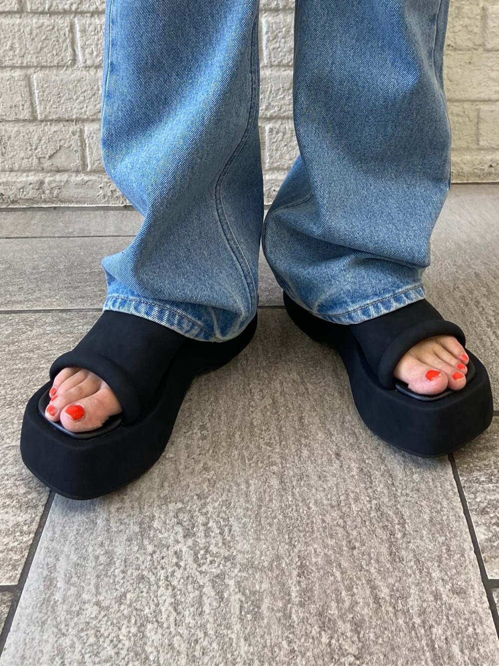 ブルー系のデニムパンツ、ブラック系のサンダル、ホワイト系のシャツ/ブラウスを着用したレディースの夏コーディネートの7枚目の写真